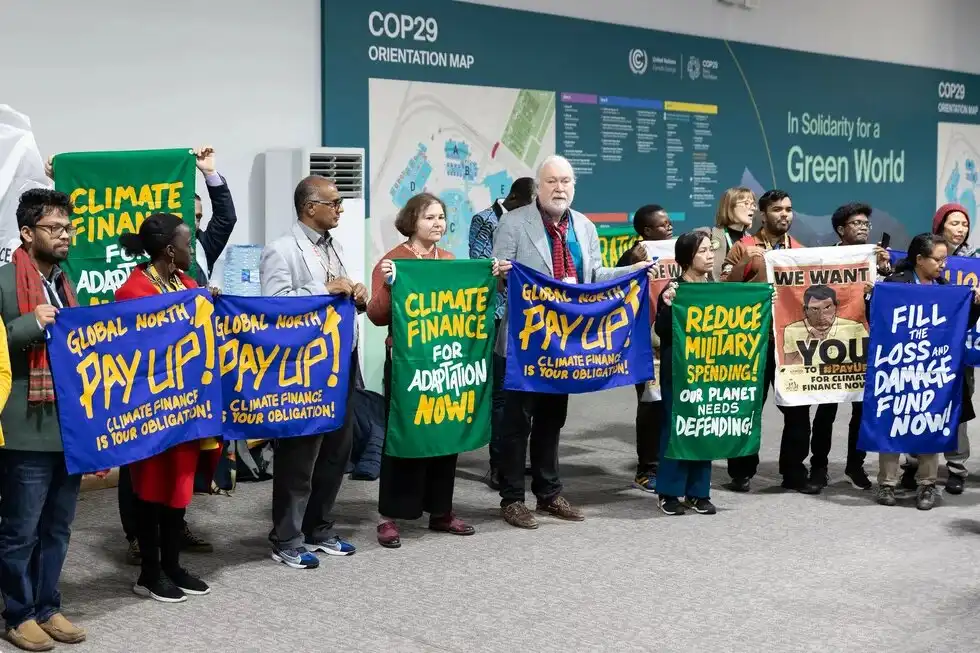 Climate protesters standing with manners at Conference of the Parities (COP) 29