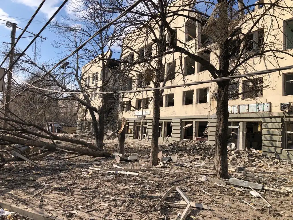 Destroyed trees and an exploded building facade