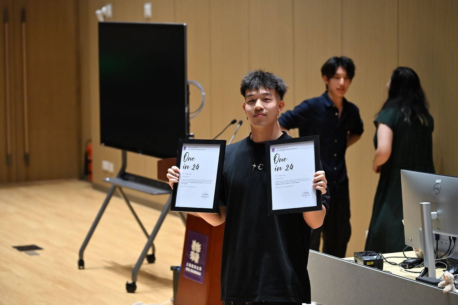 guy holding 2 framed letters
