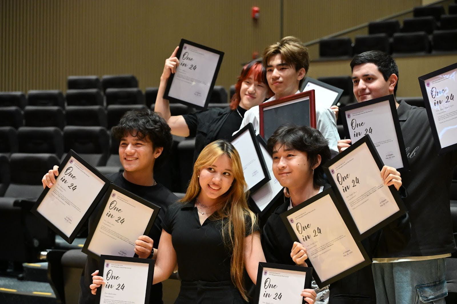 a group of people holding framed letters