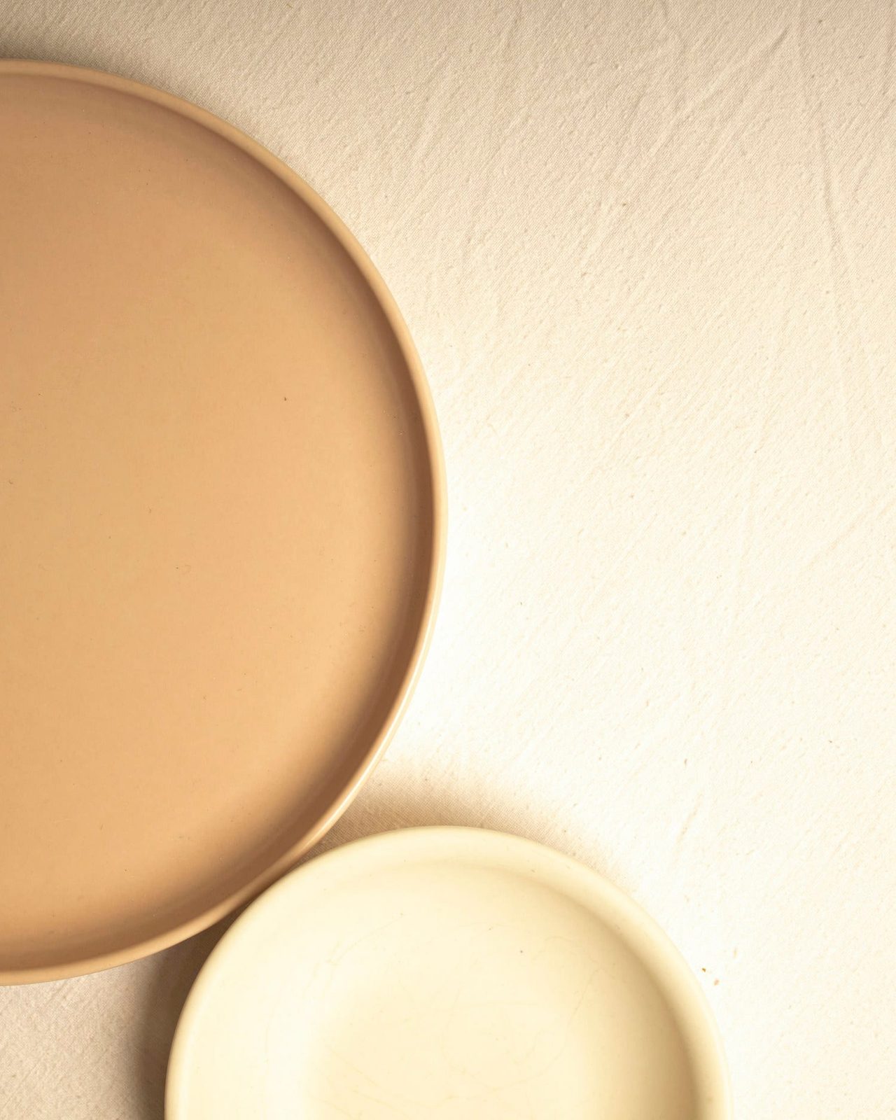 A sand-glazed plate layered over a cream charger