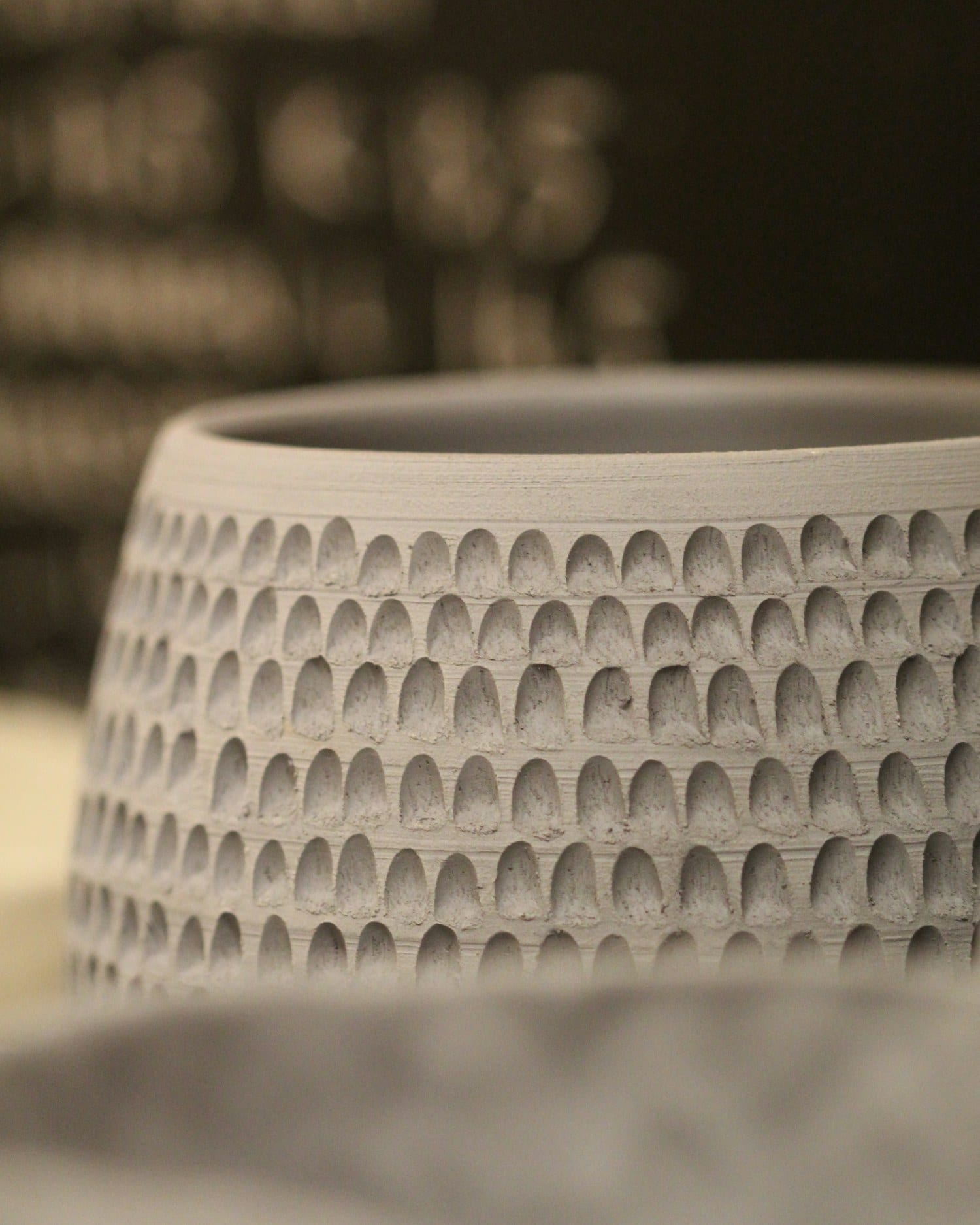 A tall vessel carved by hand with repeating vertical facets