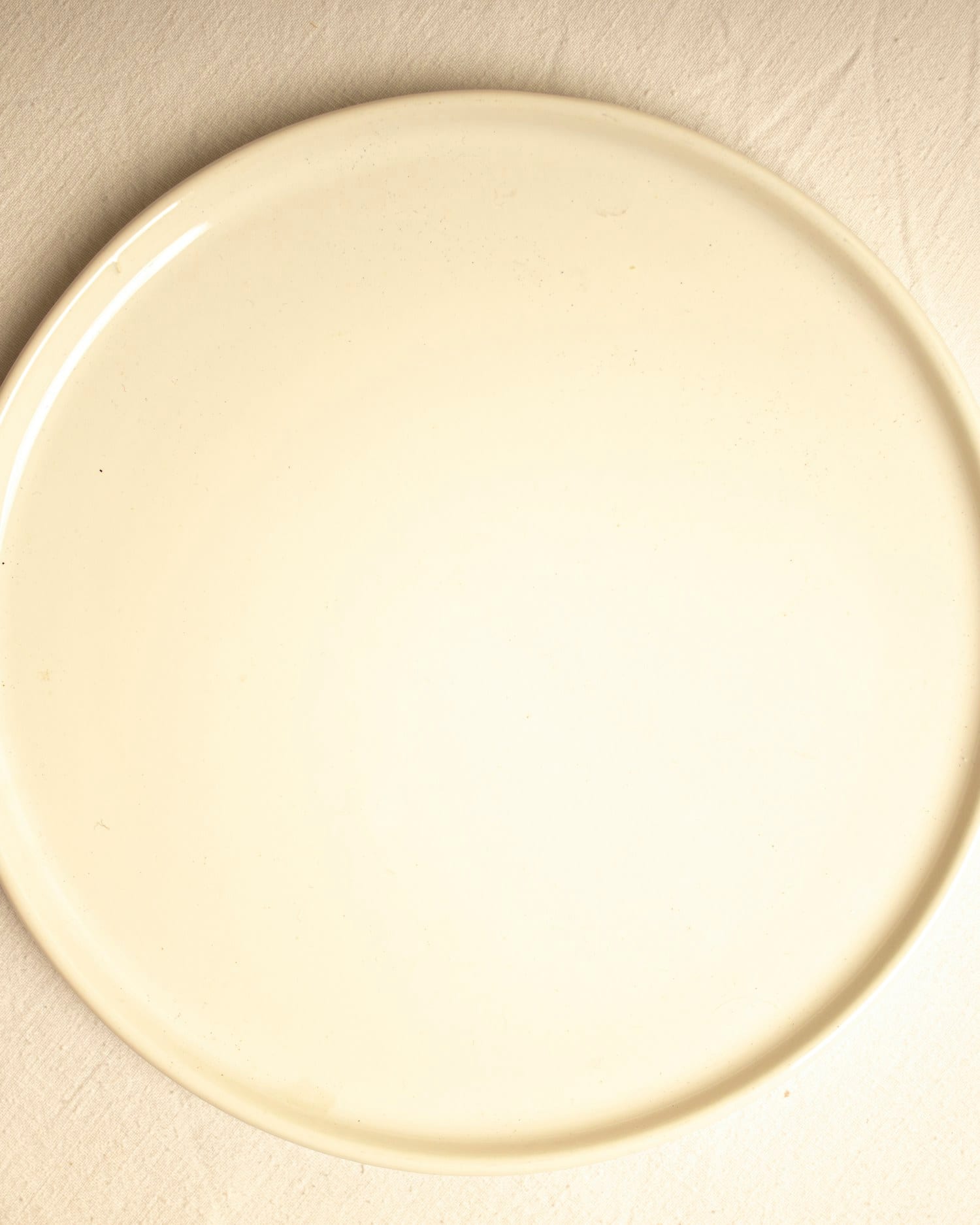 A butter-toned plate lit so the glaze appears to glow from within