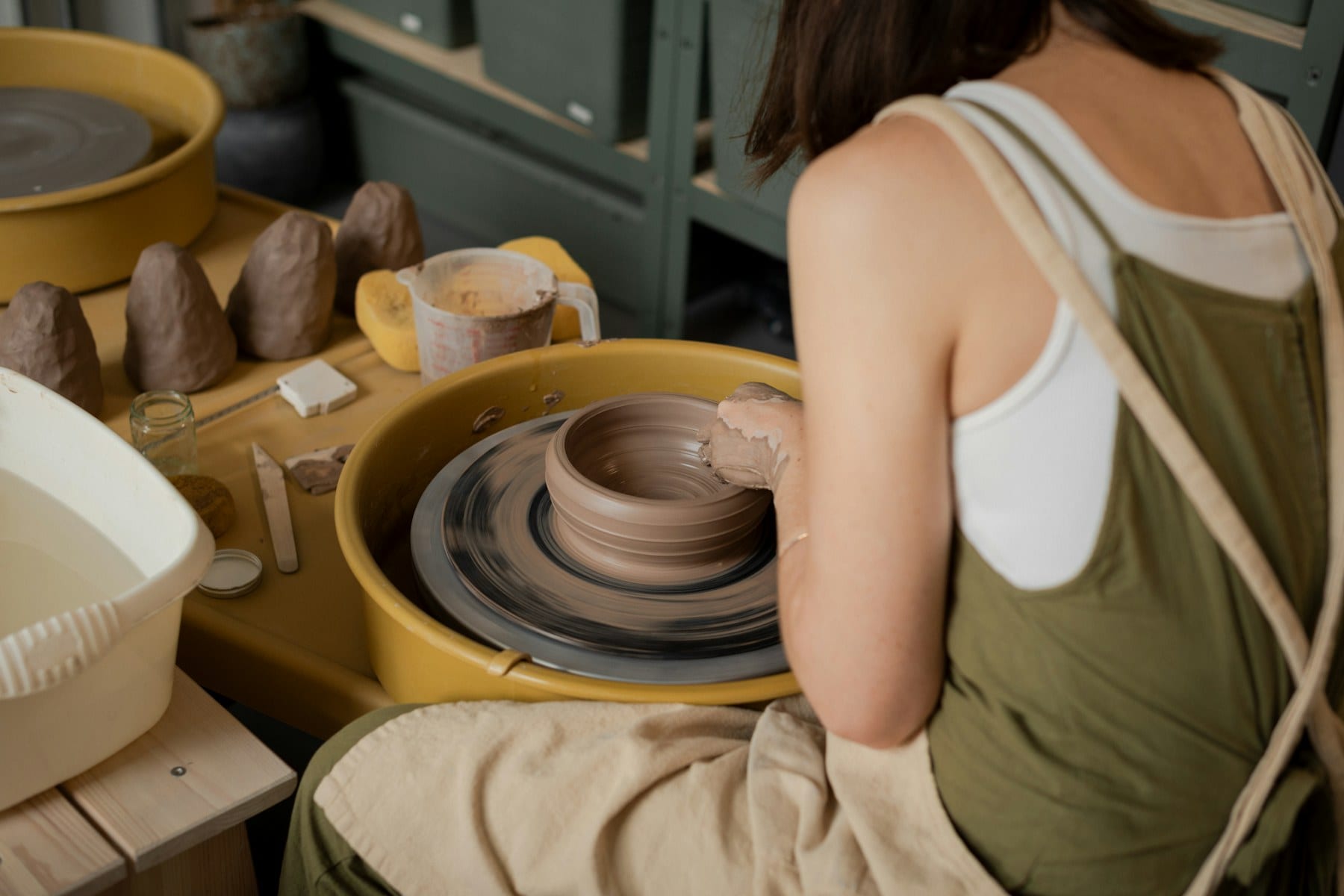 A ceramicist at work at the wheel in the studio