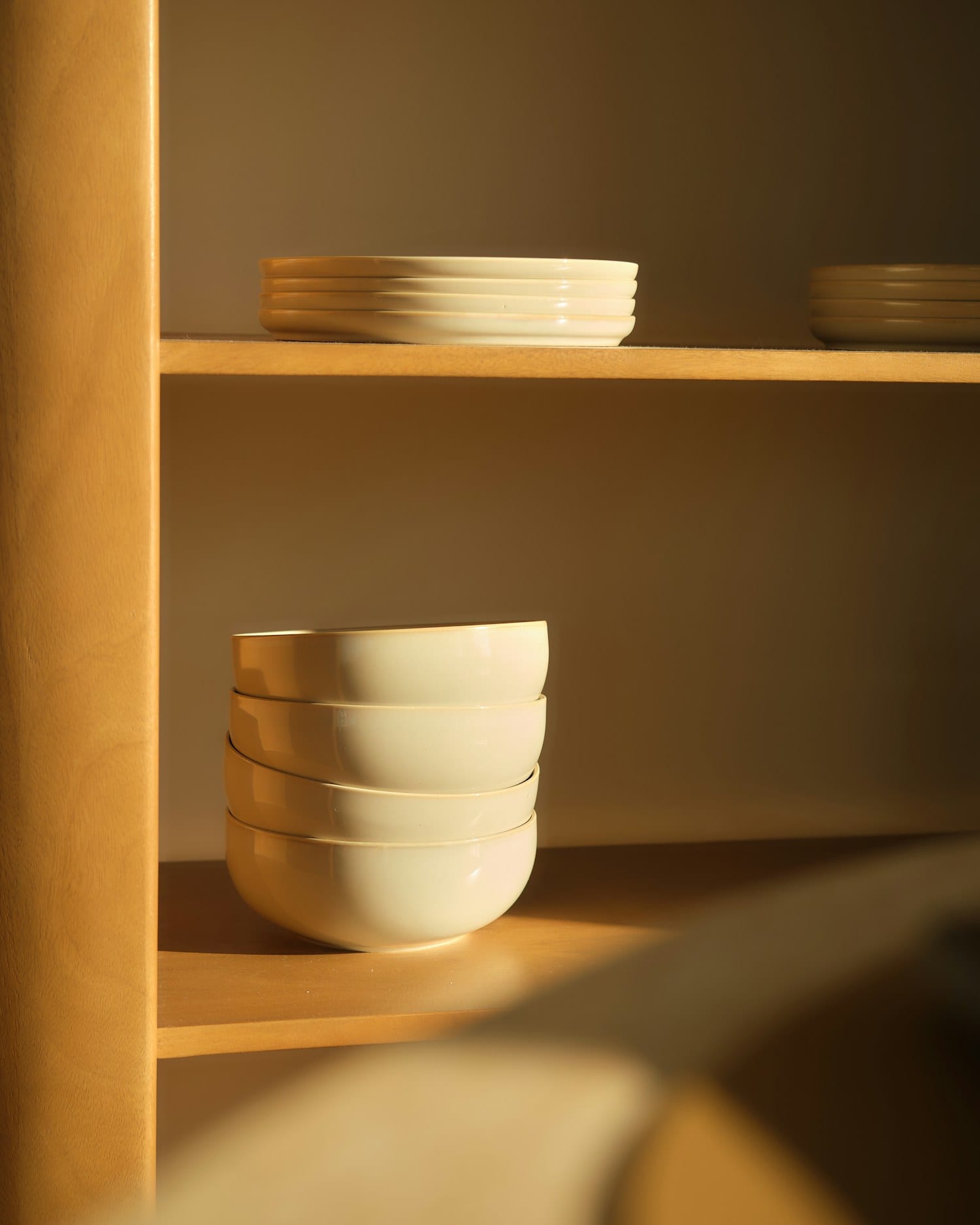 Cream bowls stacked in warm low light