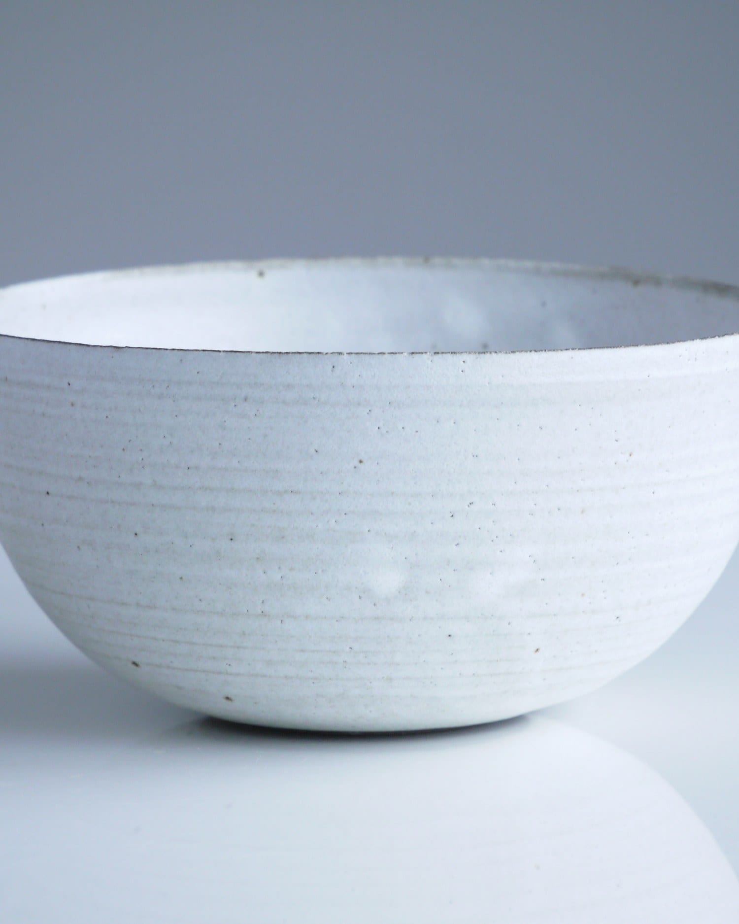 Macro study of the rim and glaze pooling inside a white bowl