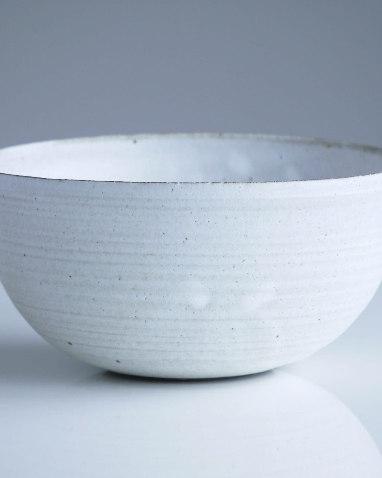 Macro study of the rim and glaze pooling inside a white bowl