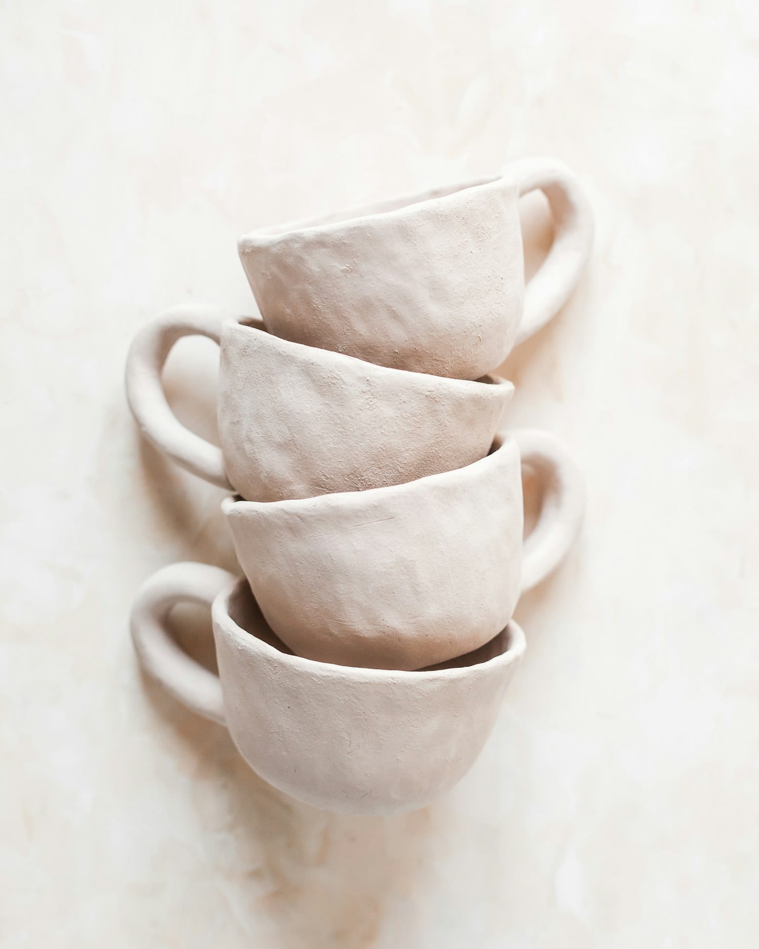 Three nude clay cups stacked at an angle