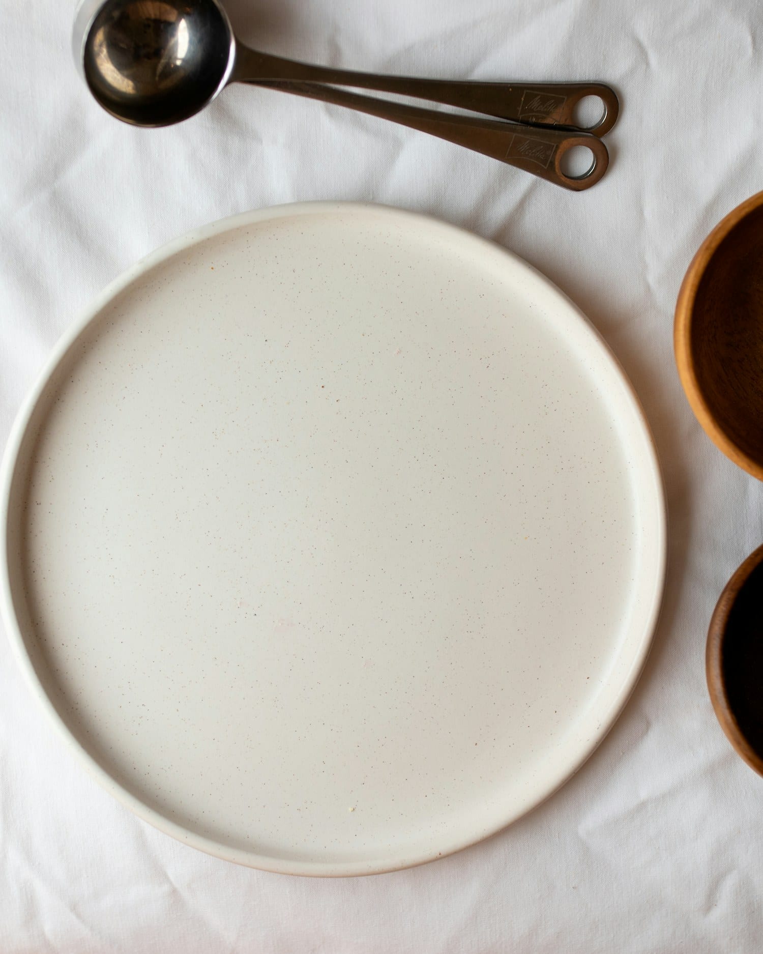A pale serving tray flanked by two chestnut-glazed bowls