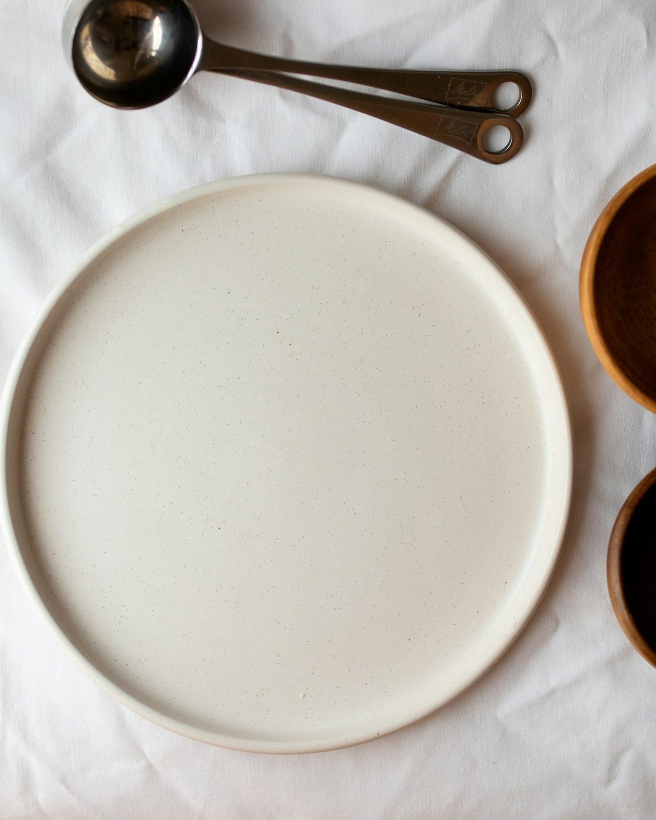 A pale serving tray flanked by two chestnut-glazed bowls