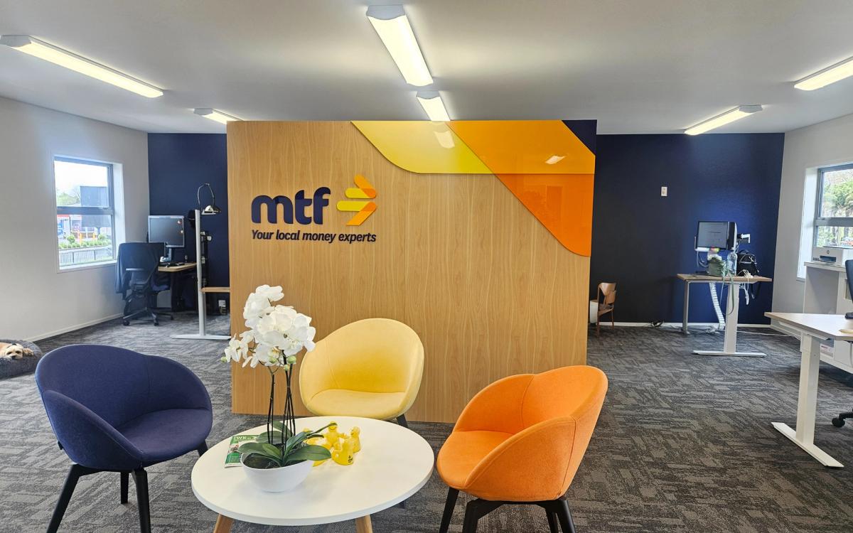 MTF Finance reception interior with 3D acrylic logo on a wood-veneer feature wall