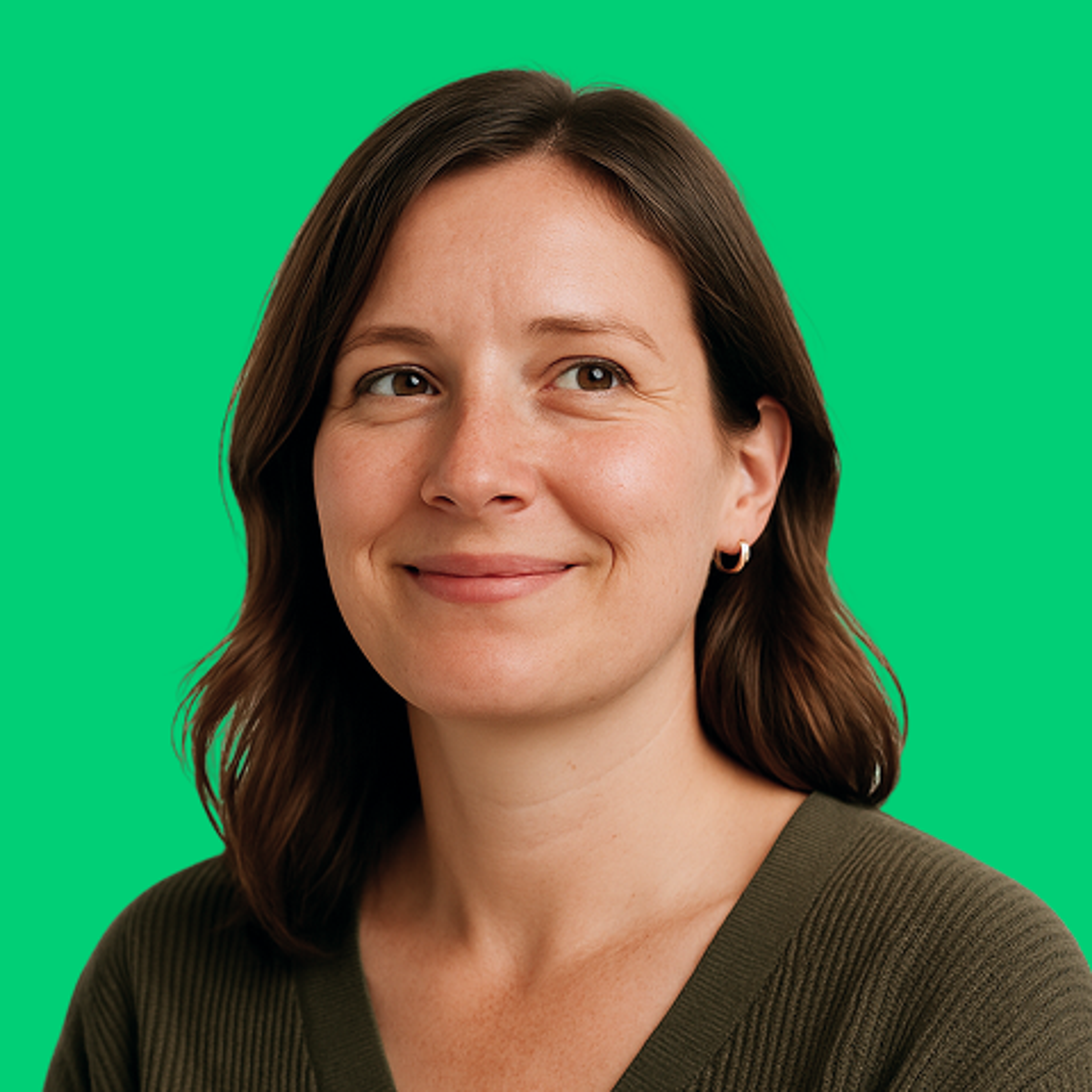 Photo of a smiling woman looking off camera with a green background