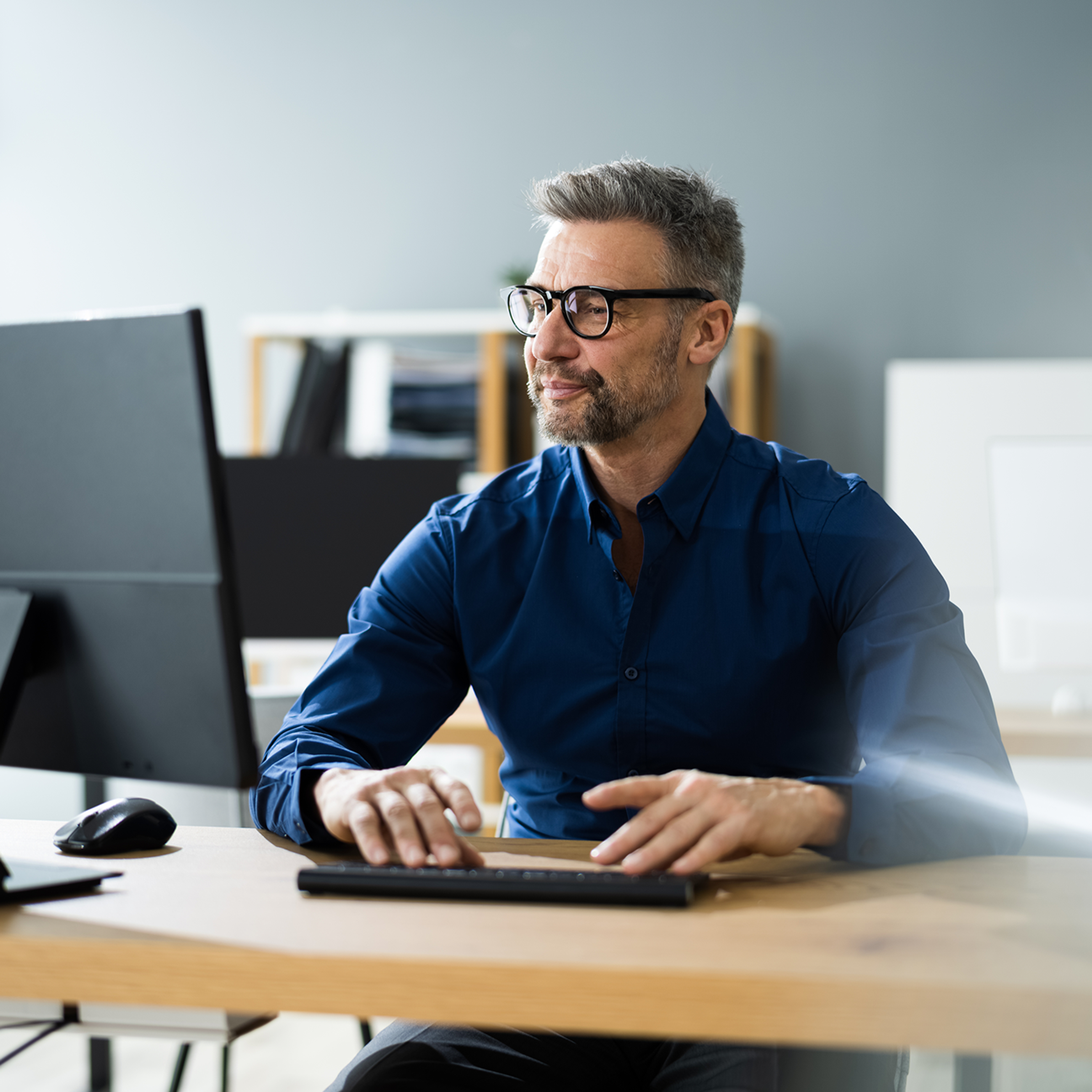 Man wearing glasses working at a computer