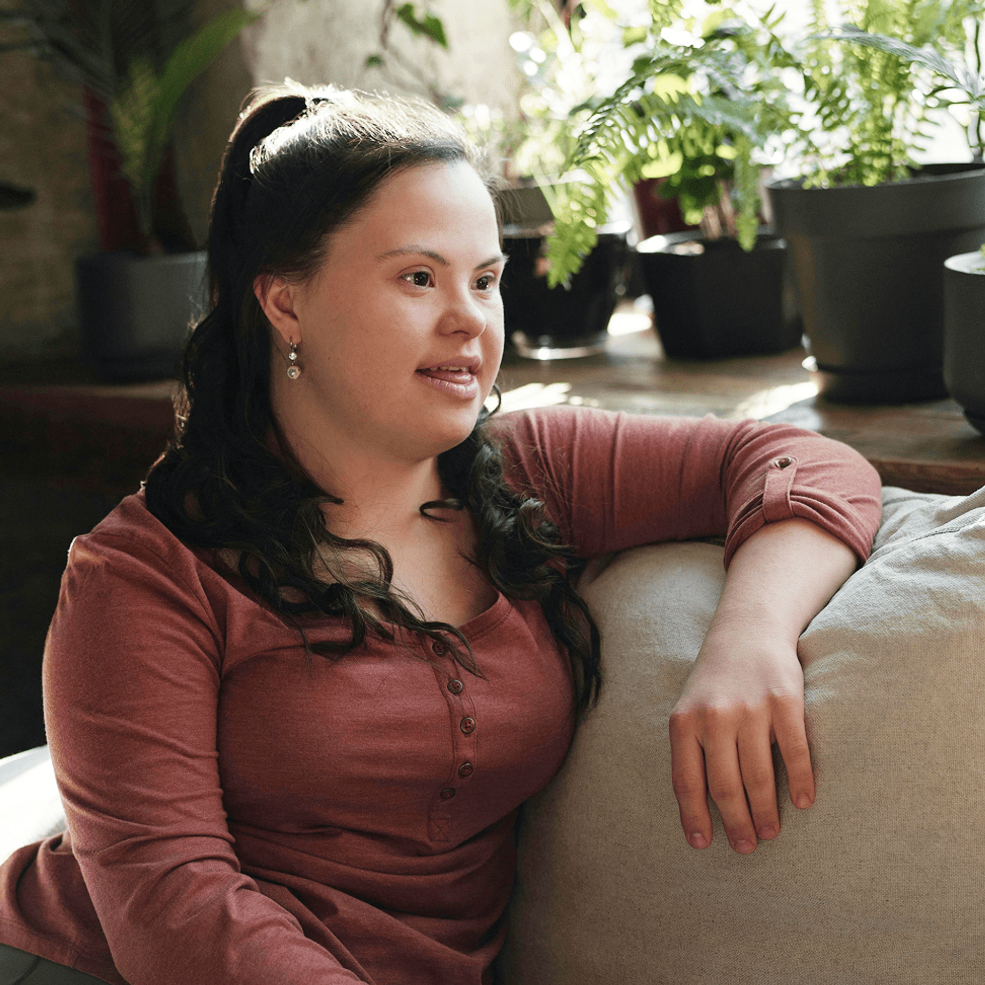 Woman with Down Syndrome sitting on a sofa