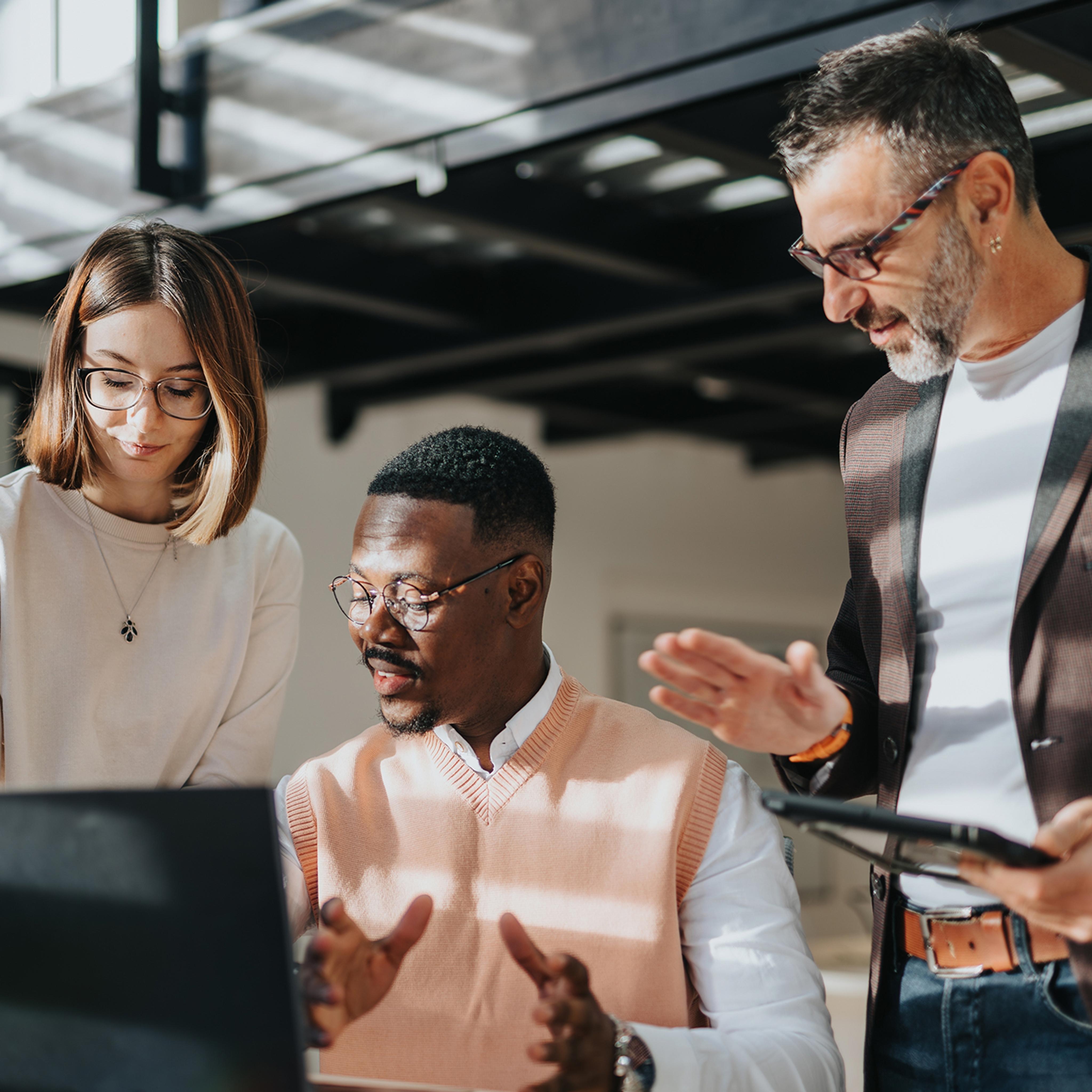 three people looking at a computer