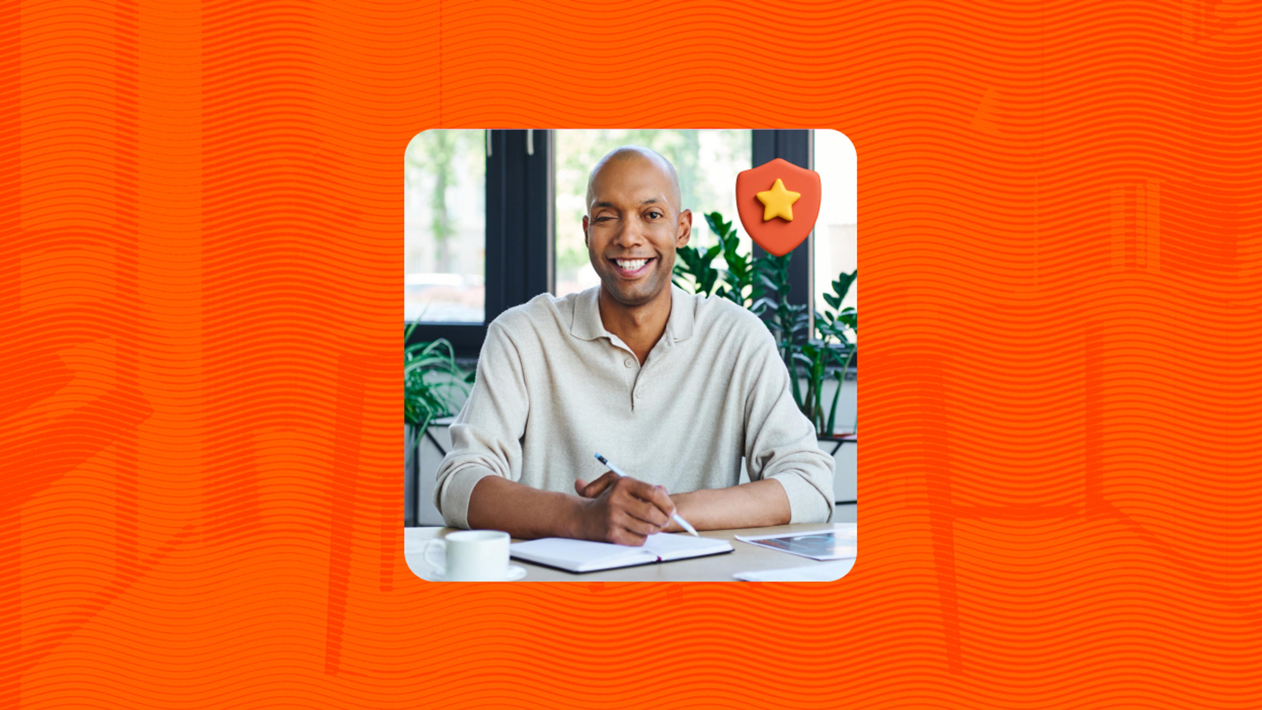 A person smiles while sitting at a desk with a notebook and pen, looking toward the camera. A small shield icon with a star appears in the corner of the image, set against an orange textured background.