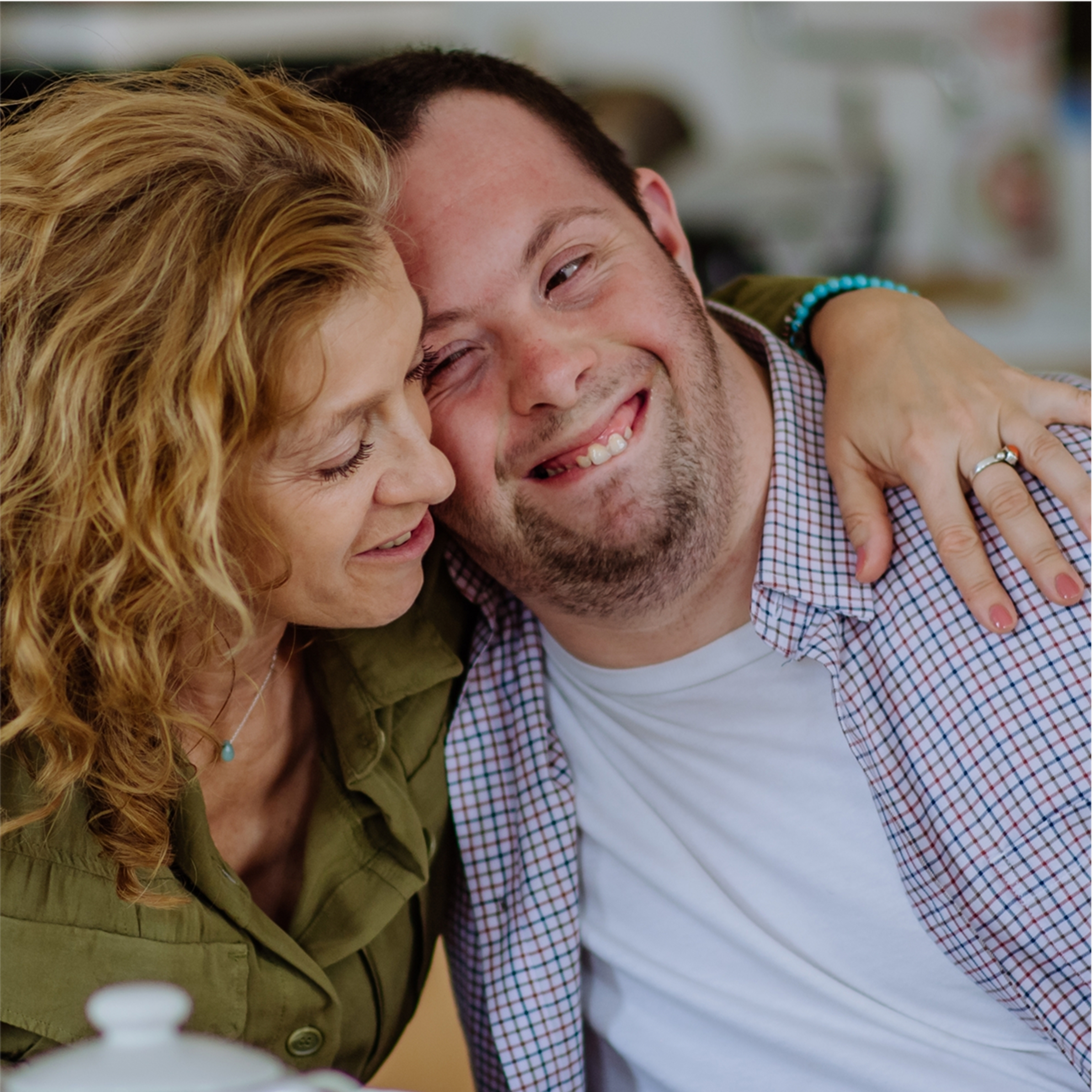 Mother hugging son with a disability