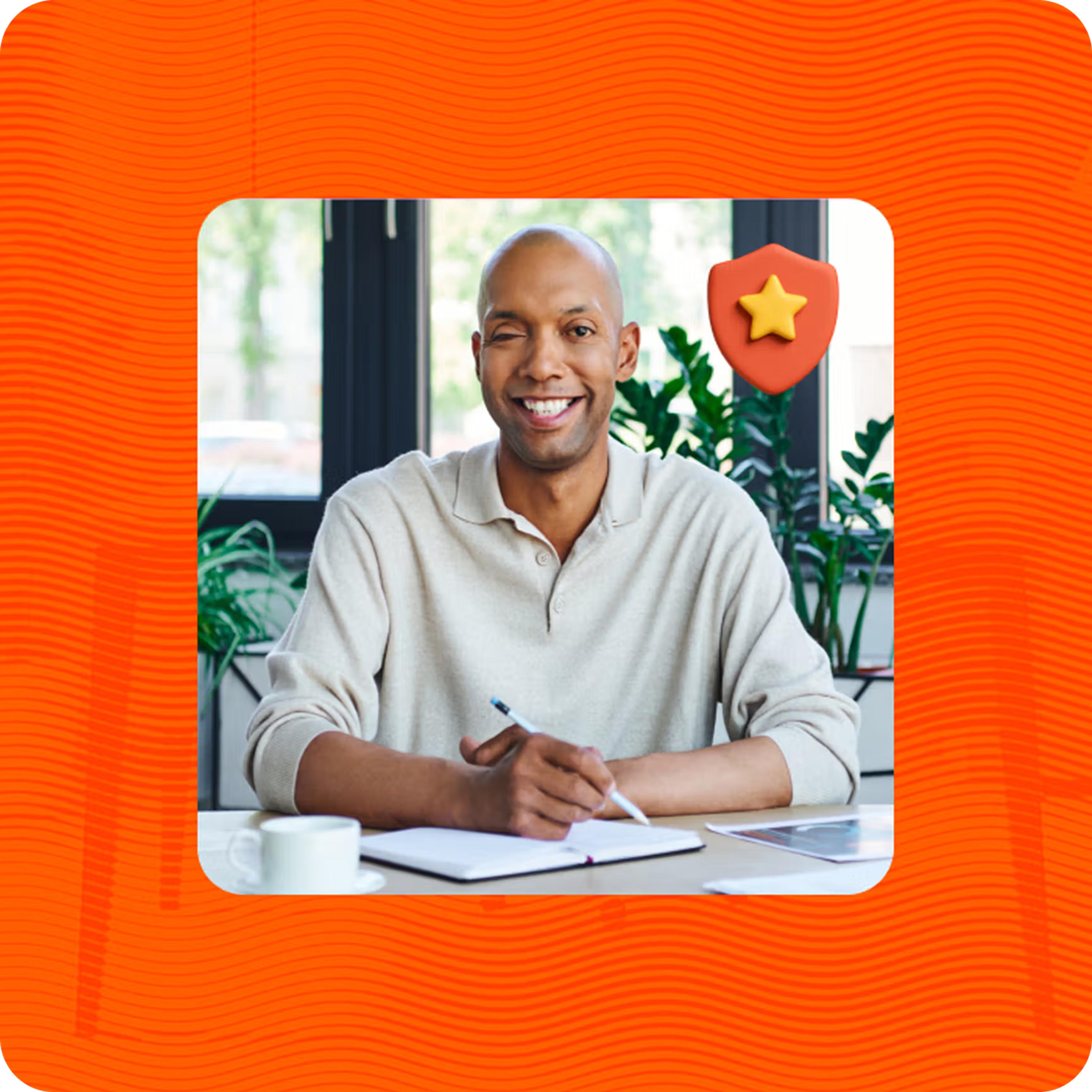 Man sitting and writing on desk at home with orange background and floating orange shield