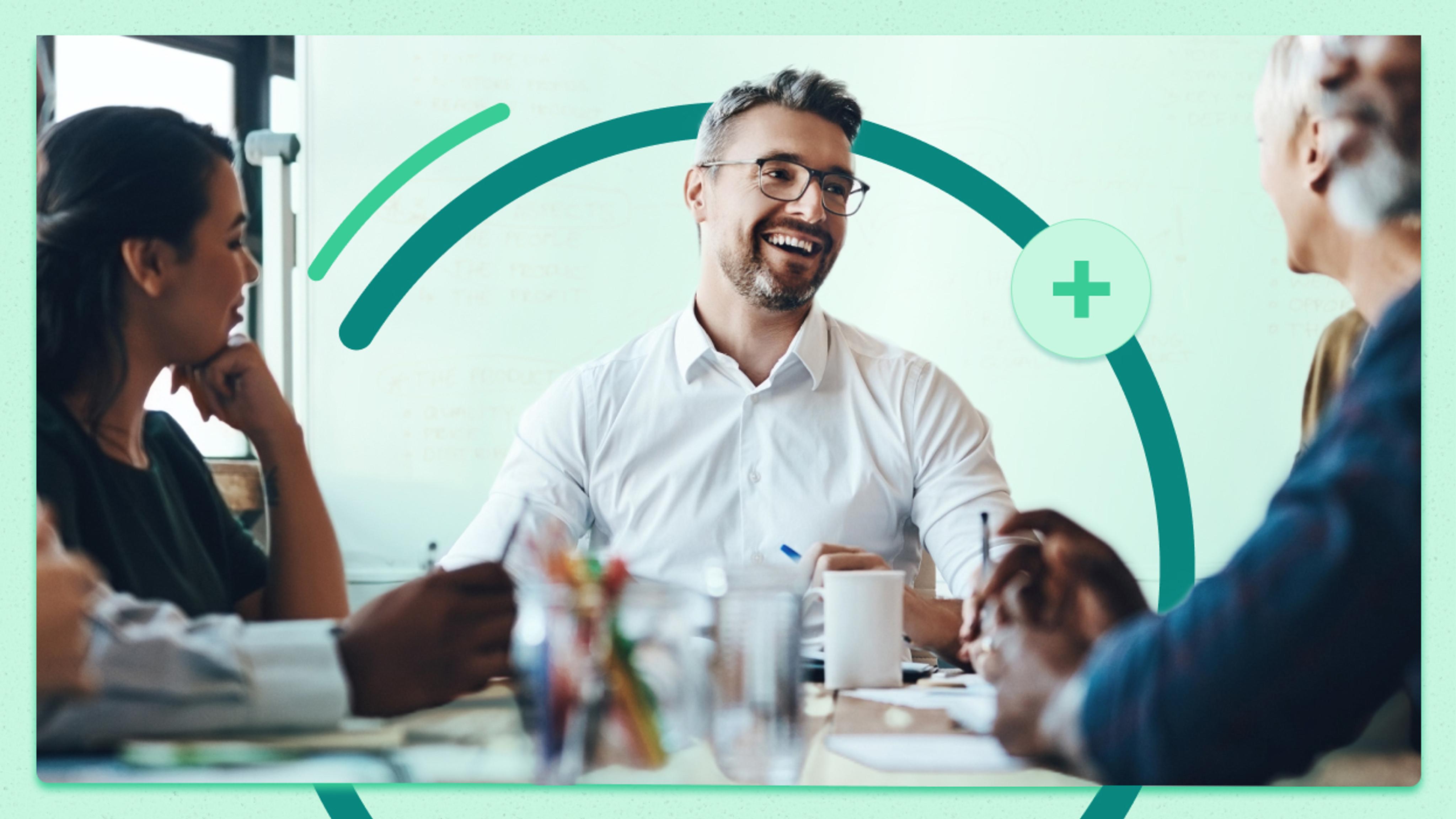 A group of business professionals having a discussion around a table. There are papers, mugs, and a pen cup on the table. A man in a white shirt is central, engaging with the others. Graphic overlays of circles and a plus sign are present.