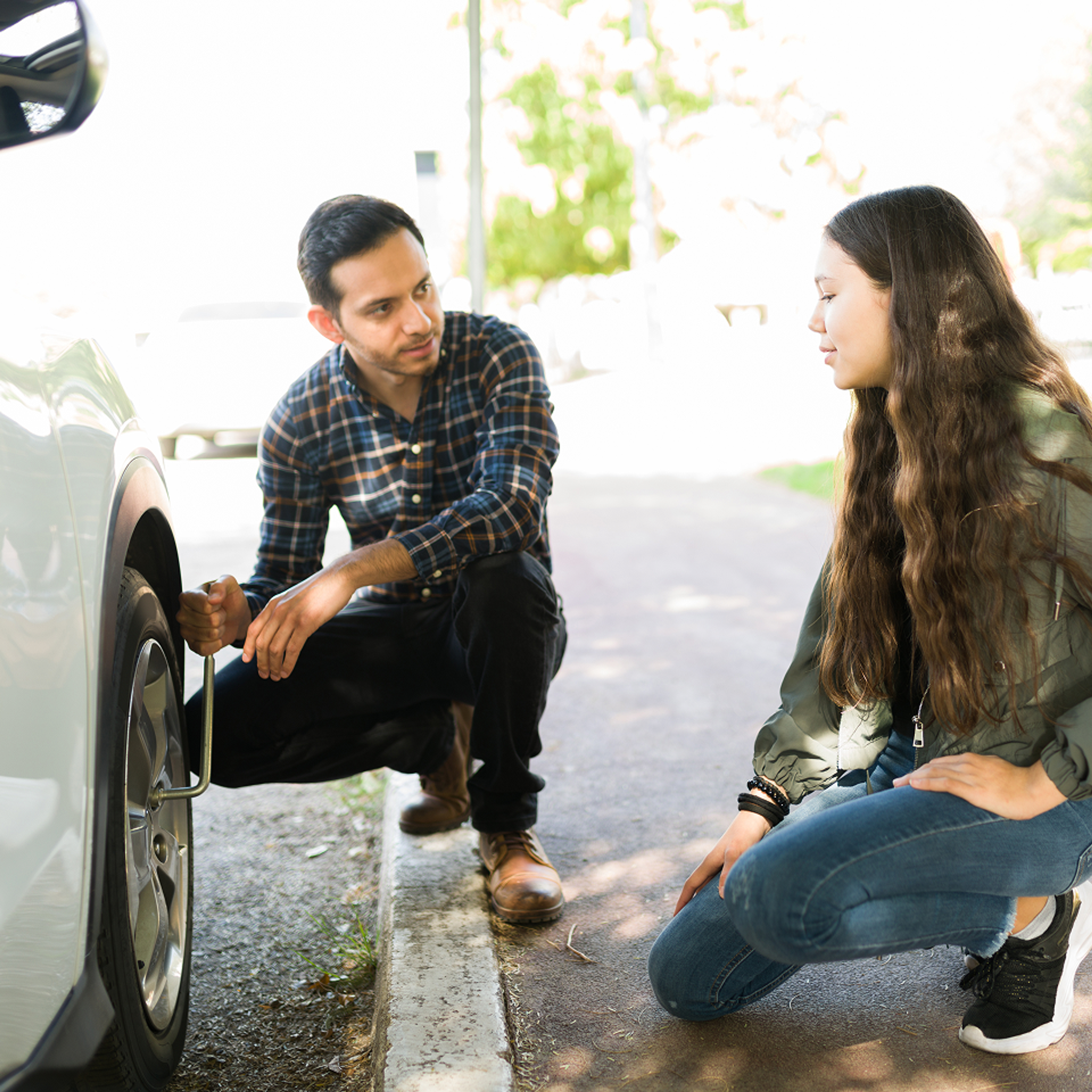 Man helps woman with a flat tire