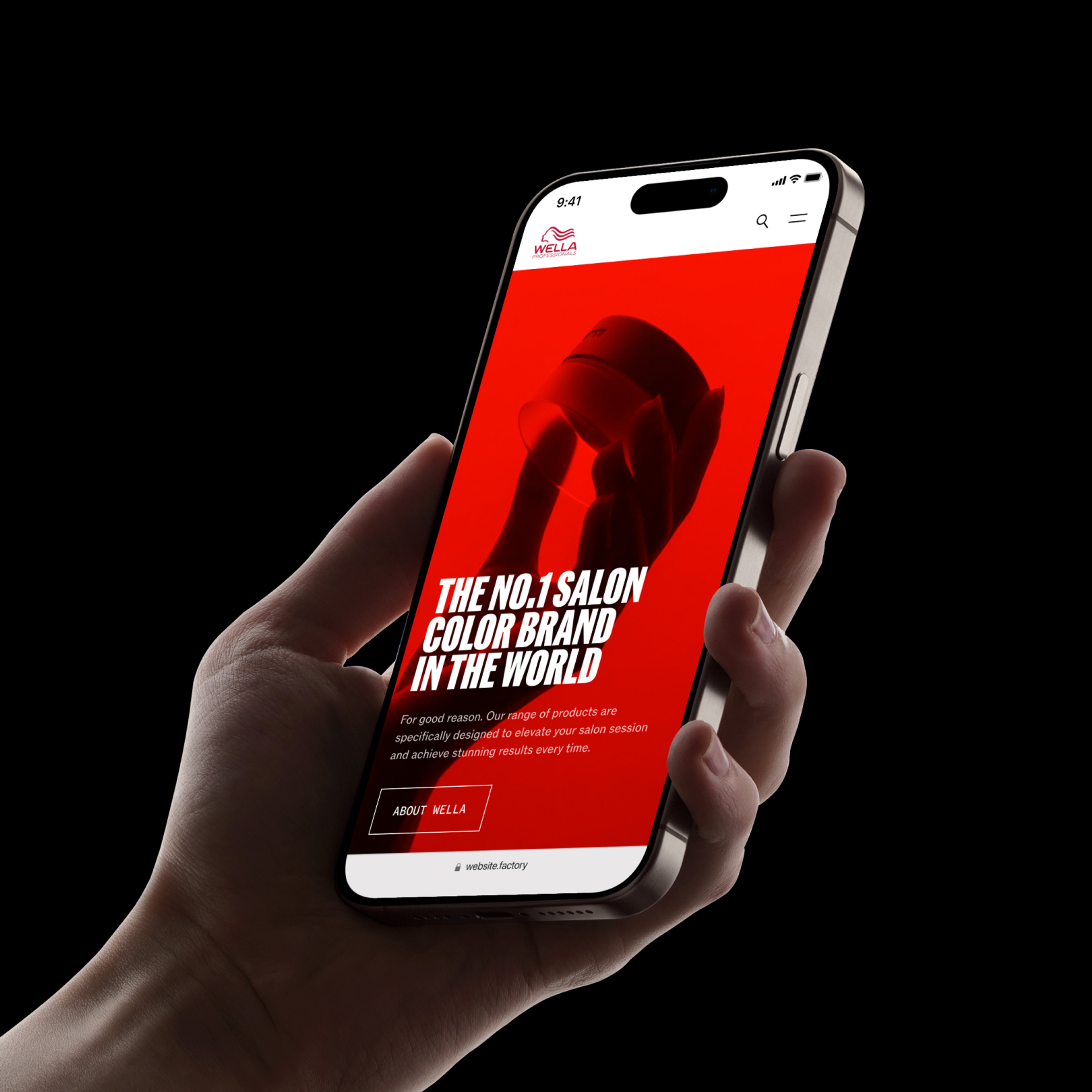 Hand holding an iPhone displaying the Wella Professionals homepage with a bold red hero and "The No.1 salon color brand in the world" headline