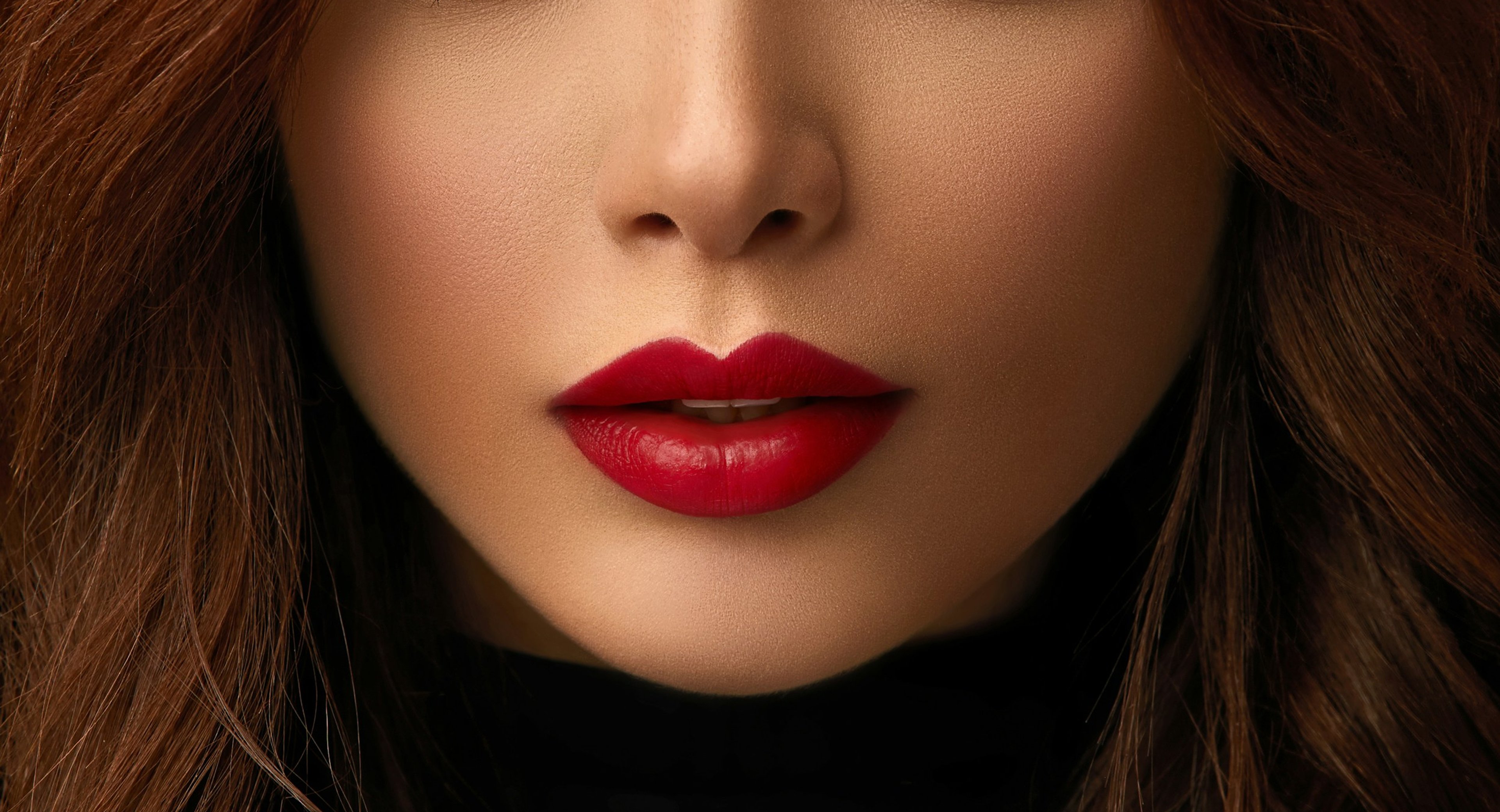 Close-up of a woman’s lips with smooth skin and bright red lipstick