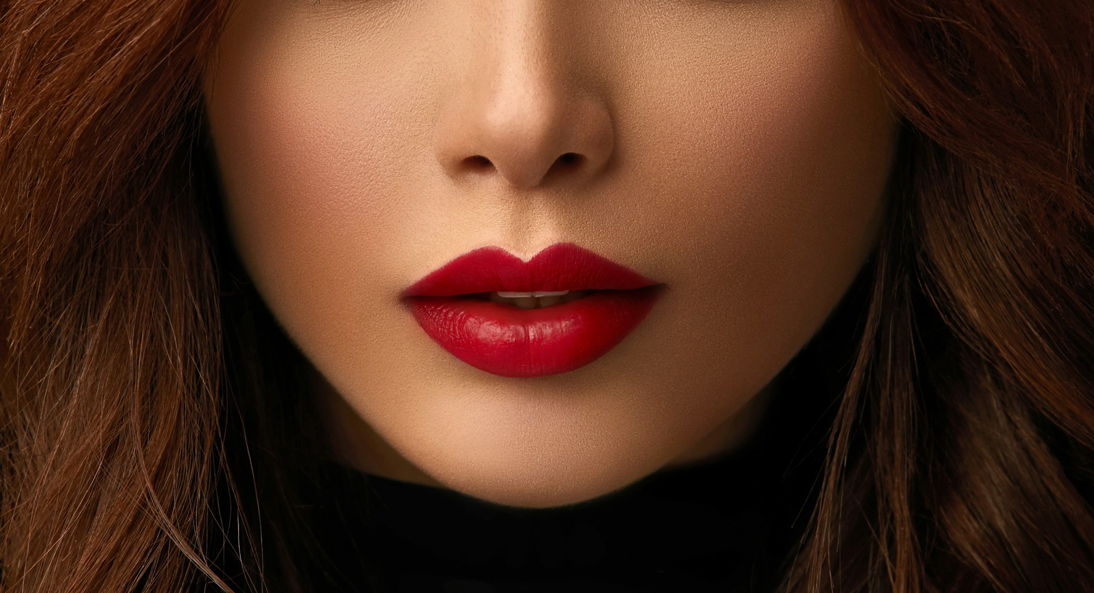 Close-up of a woman’s lips with smooth skin and bright red lipstick