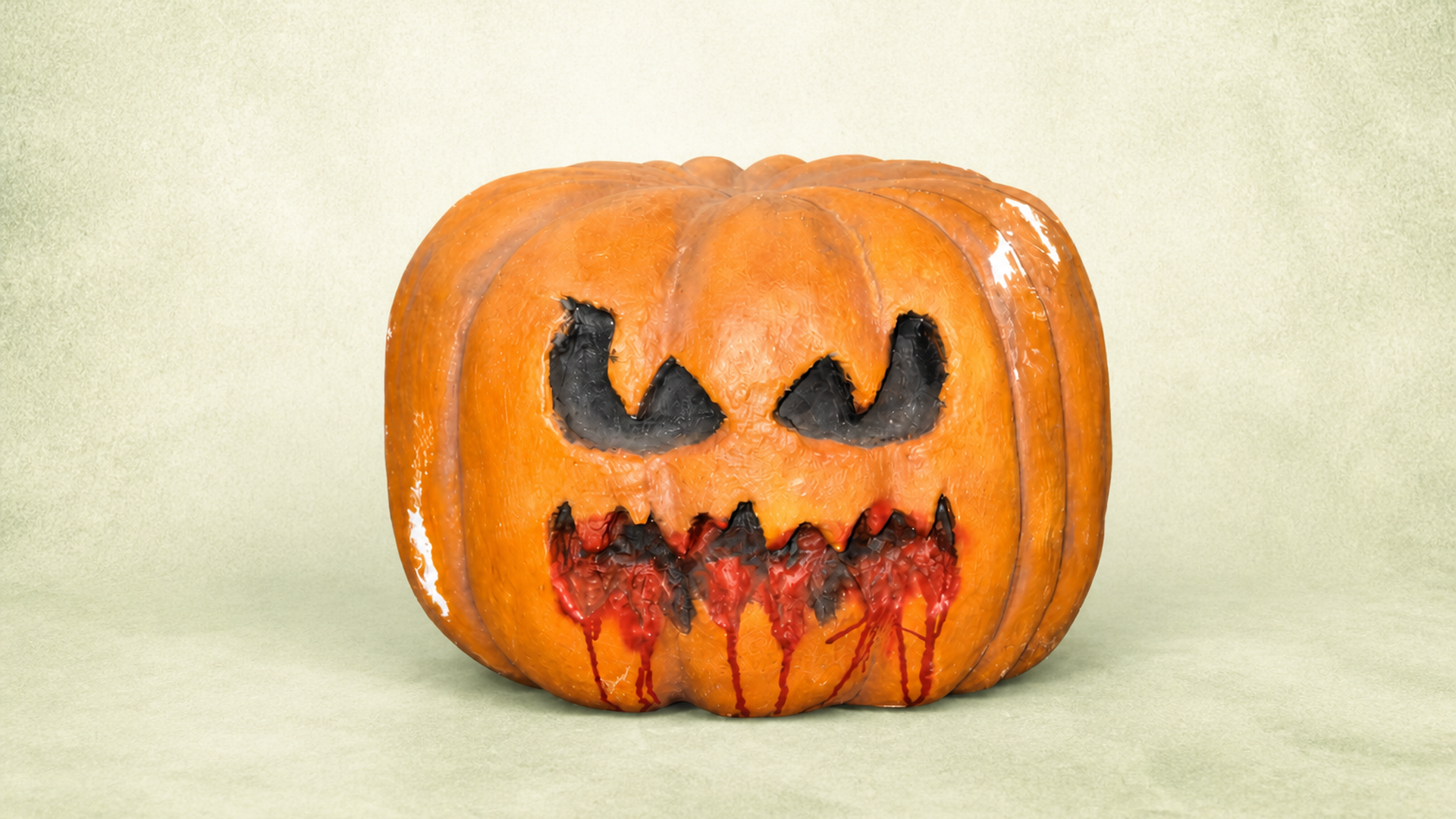 Large spooky Halloween pumpkin prop with carved face and dripping blood effect