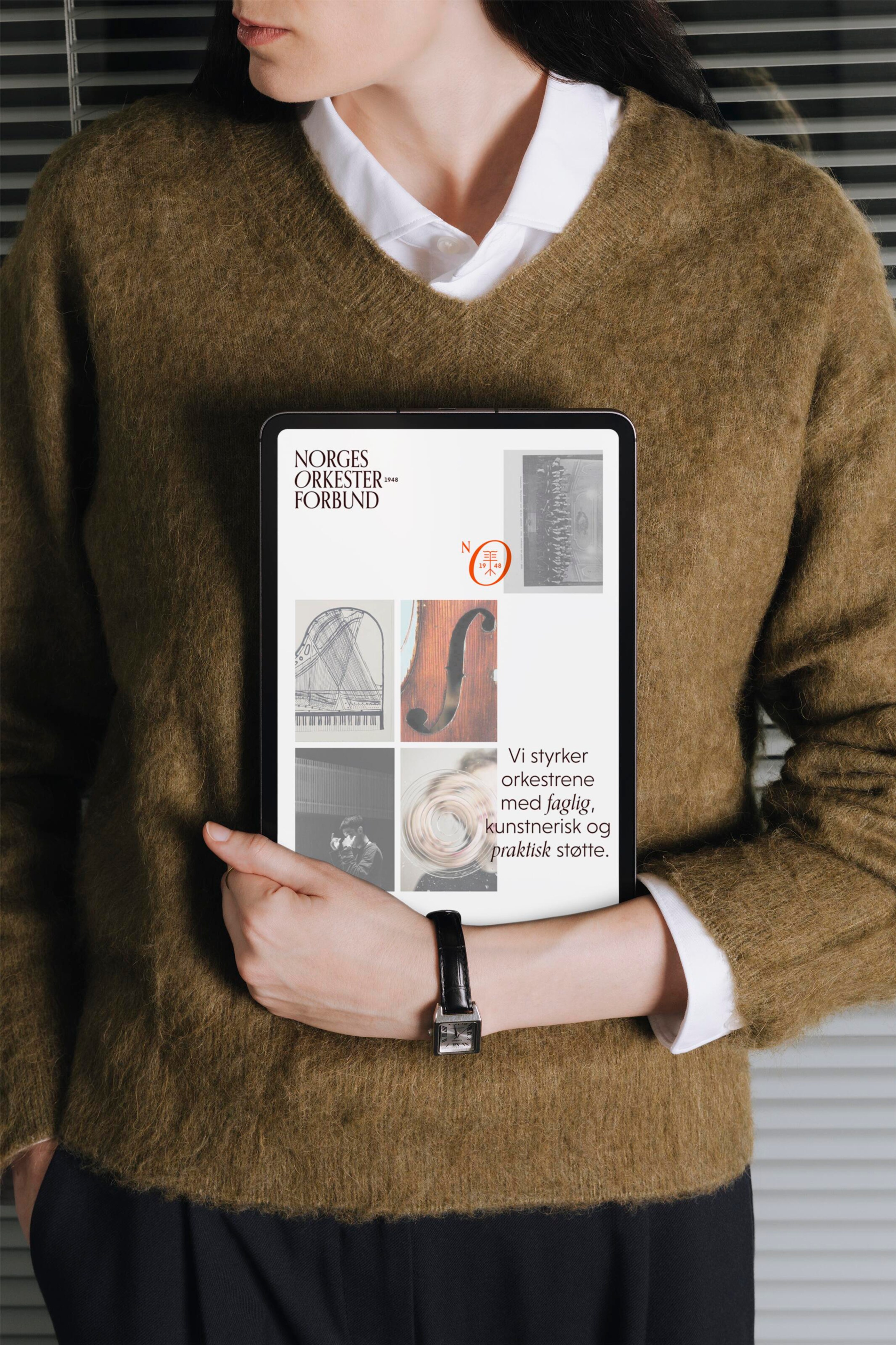Person holding a tablet displaying the Norges Orkesterforbund identity, archive imagery and a statement about supporting orchestras.
