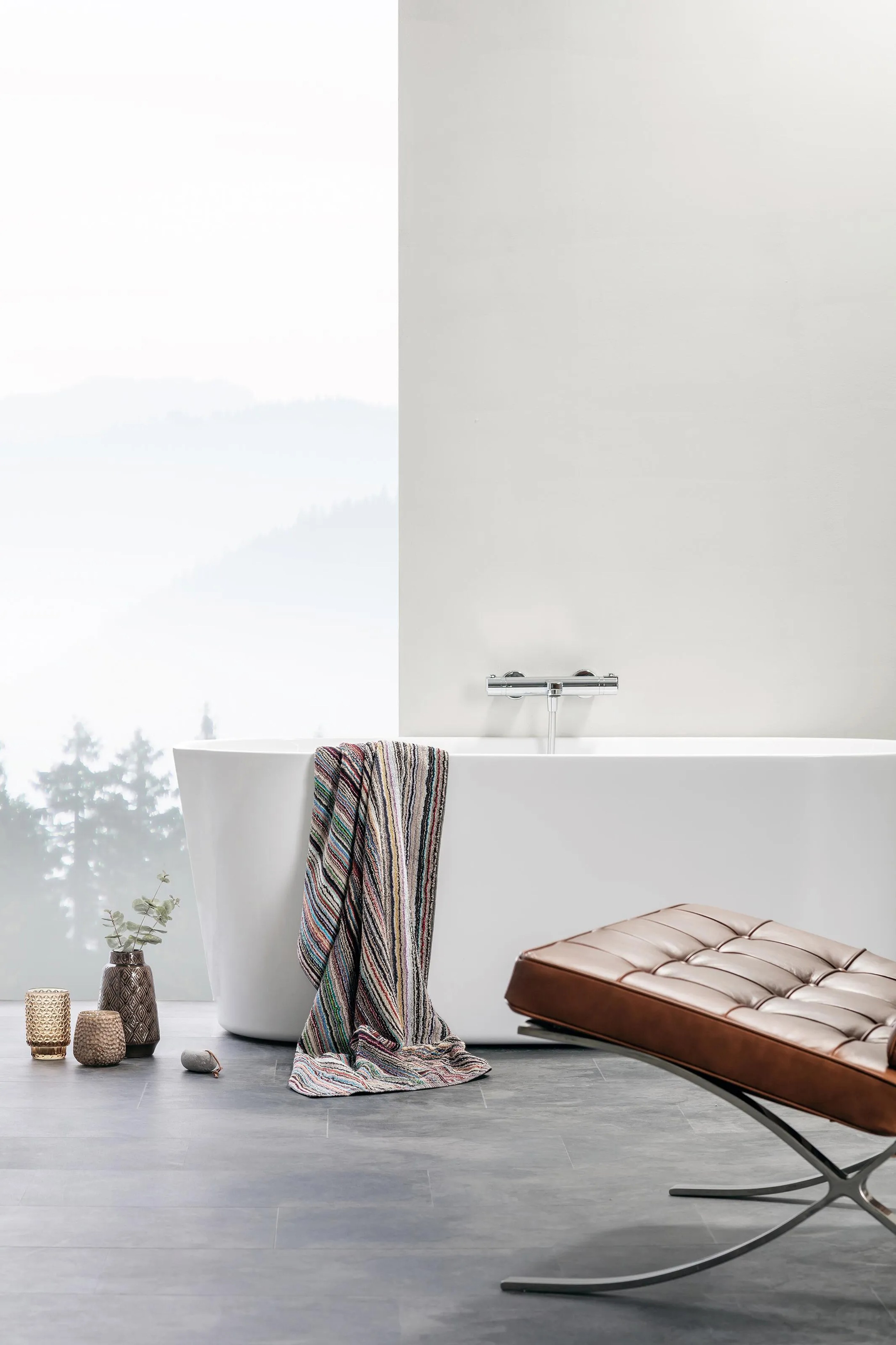 Contemporary minimalist bathroom featuring Alterna wall-mounted mirror cabinet in light oak frame, white vanity unit with integrated wood drawers, polished chrome mixer tap, white subway tiles, and grey terrazzo floor tiles.