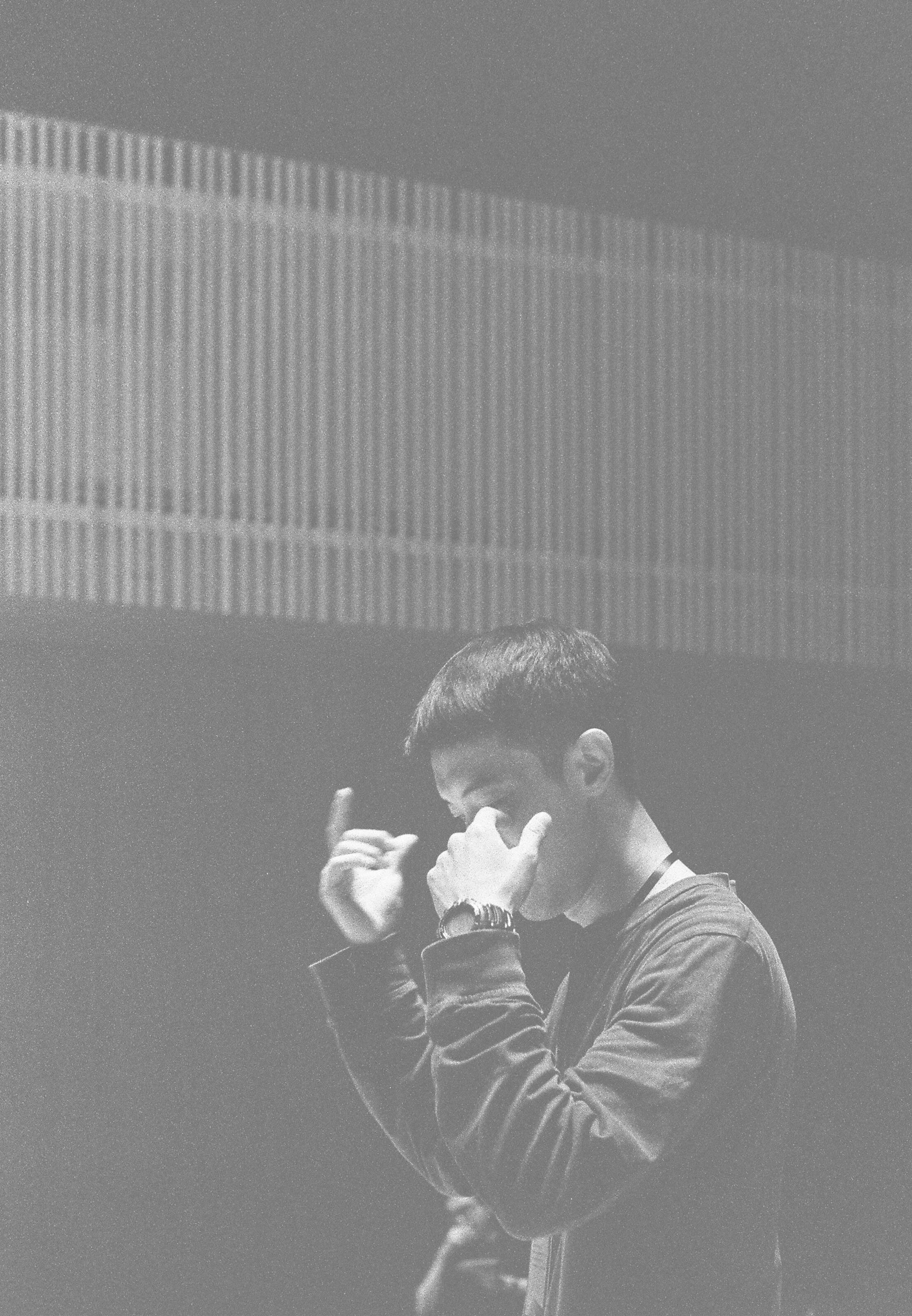 Black-and-white photograph of a conductor gesturing with both hands during a rehearsal.