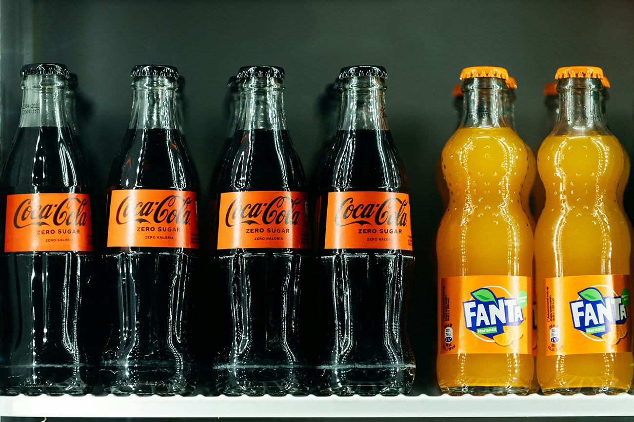 Two drinks, two personalities: Coca‑Cola embodies sleek sophistication, while Fanta bursts with playful energy – a reminder that a brand's character starts long before the logo.