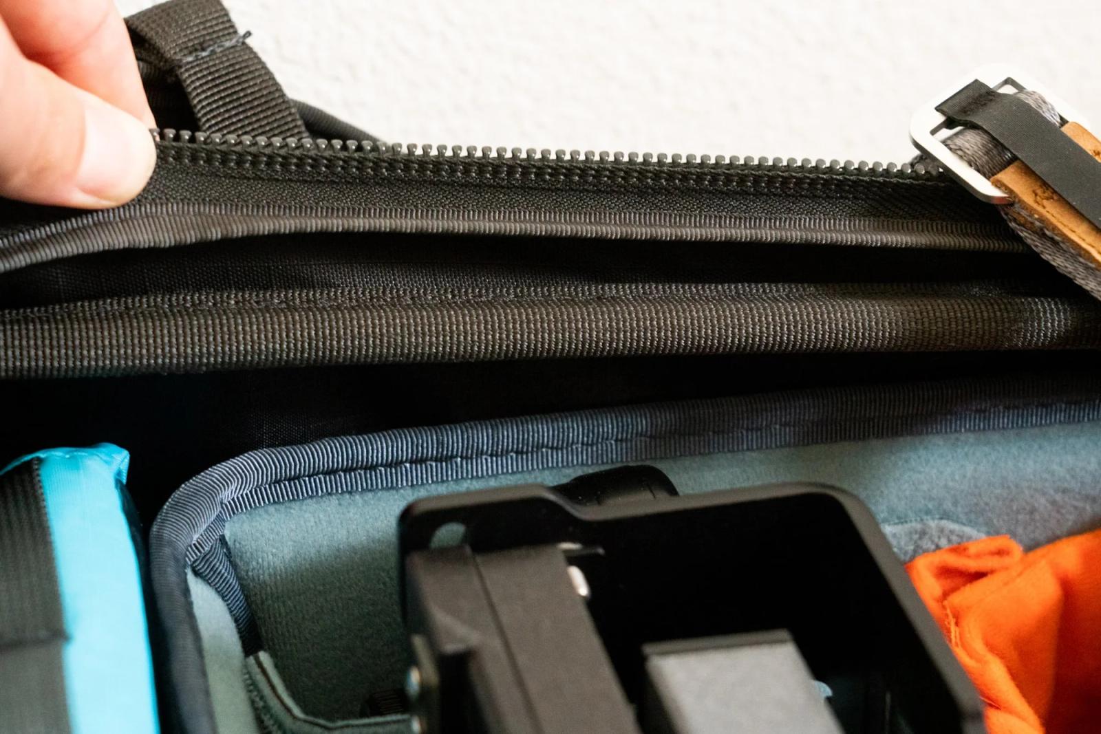 The extra material in question. The Shimoda Action X50 has more room than the insert provides. When pulled fairly gently, both the backpack material and the zipper extend by quite a fair amount. When closed up, the camera itself forces that extra little bit of expansion, and is safe in doing so since it is the metal baseplate providing all the support.