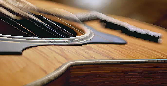 A close-up view of an acoustic guitar with a microphone positioned near the sound hole, showcasing the wood grain and strings under warm lighting.