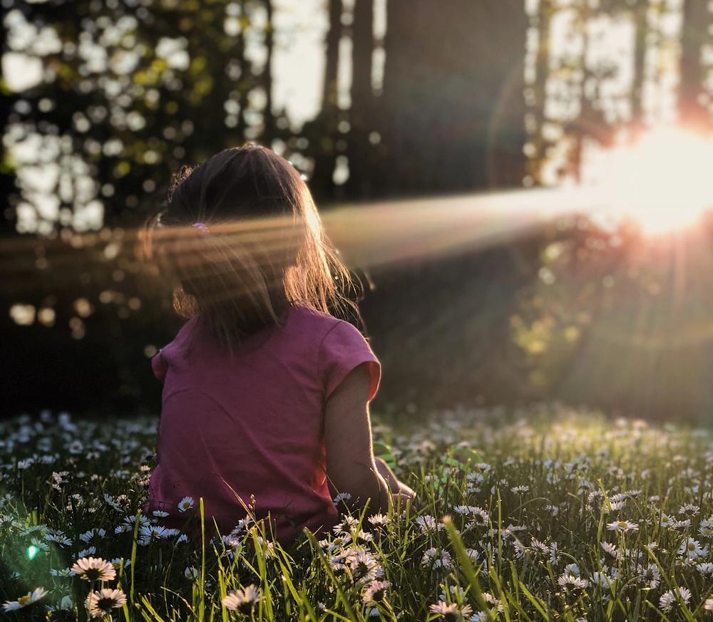 Little girl sitting in forest