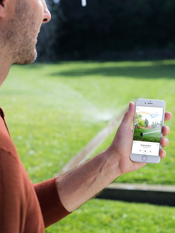Person using Rachio app in their yard
