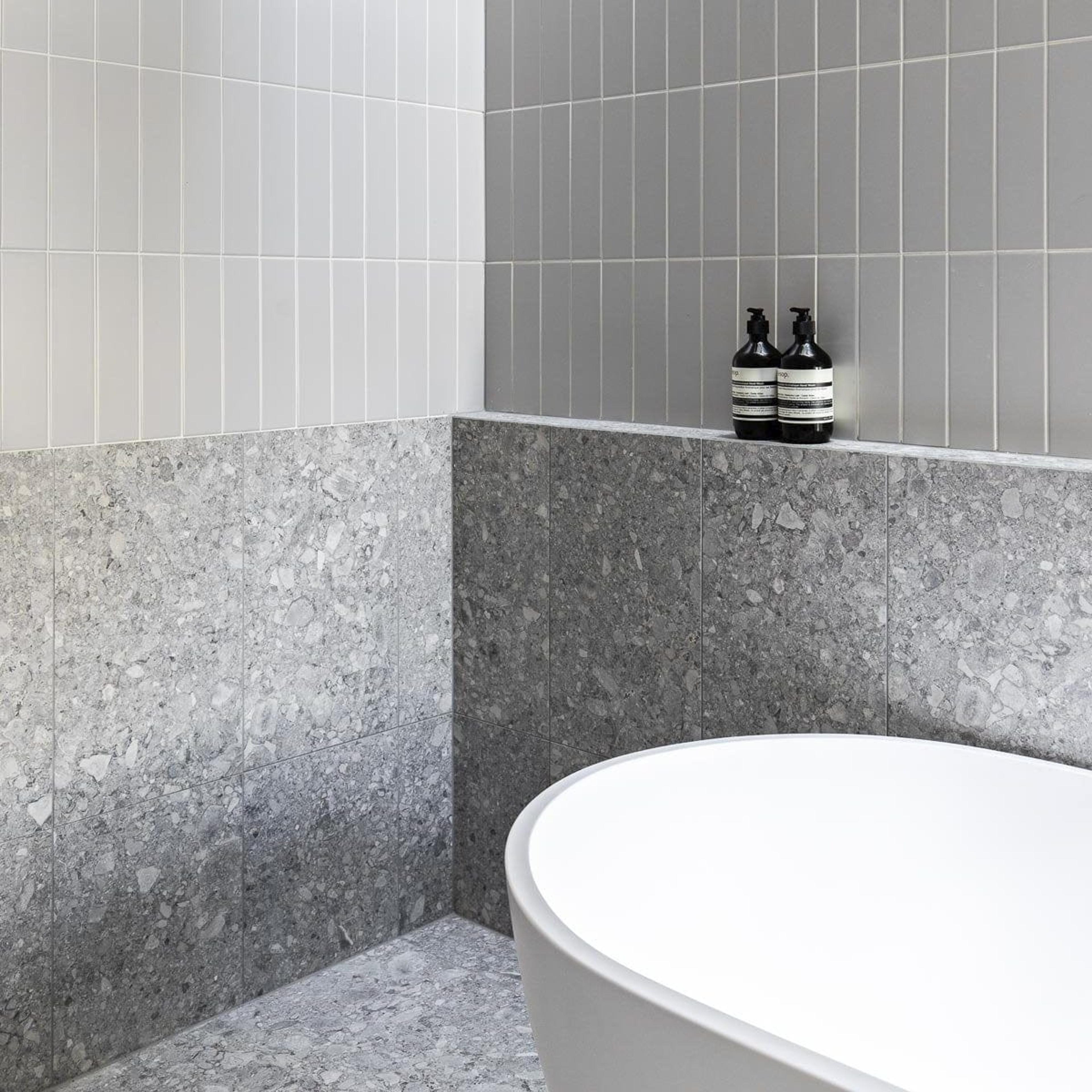 Modern gray designed bathroom with patterned tiles and a bathtub