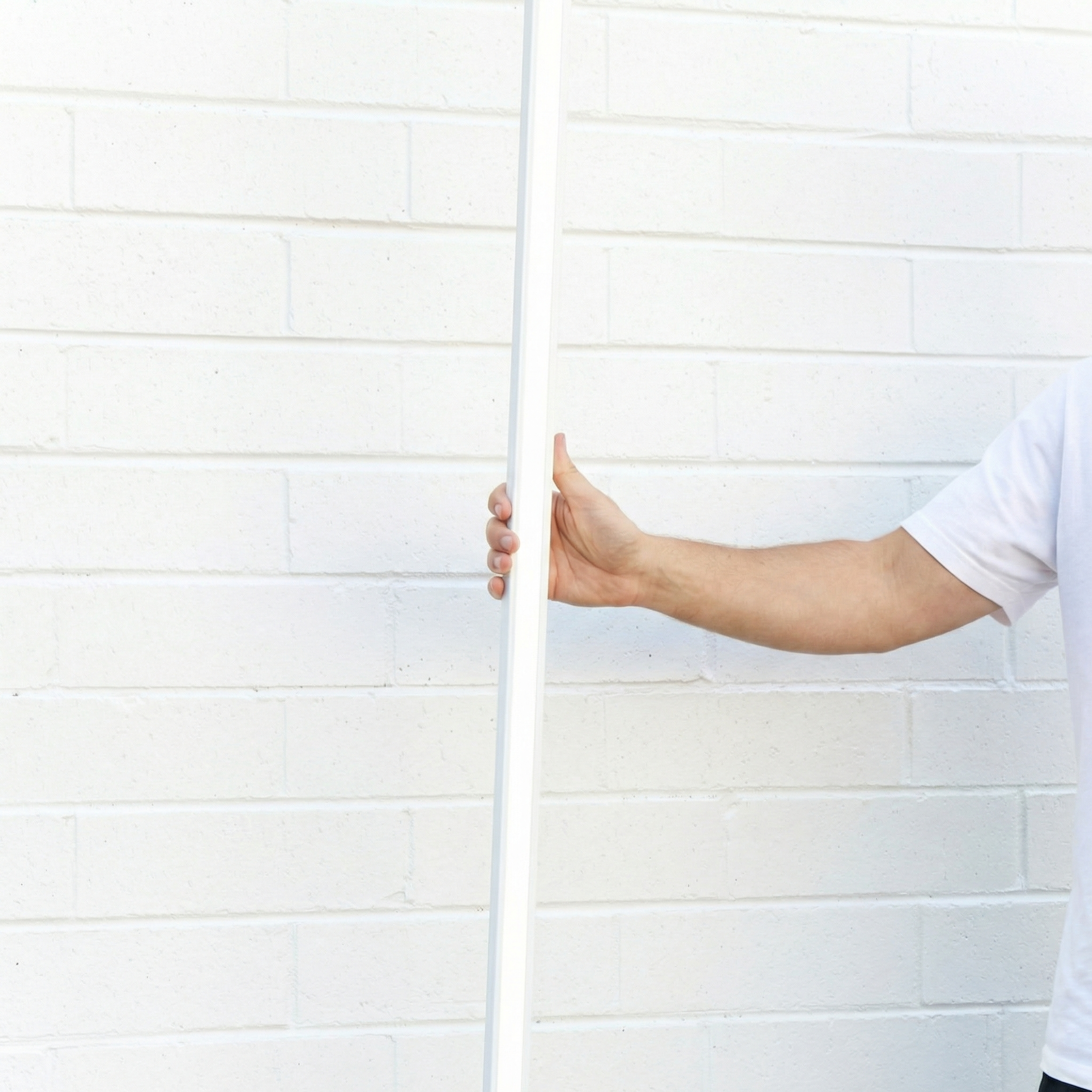 Darlinghurst White Track light held upright against a white brick wall