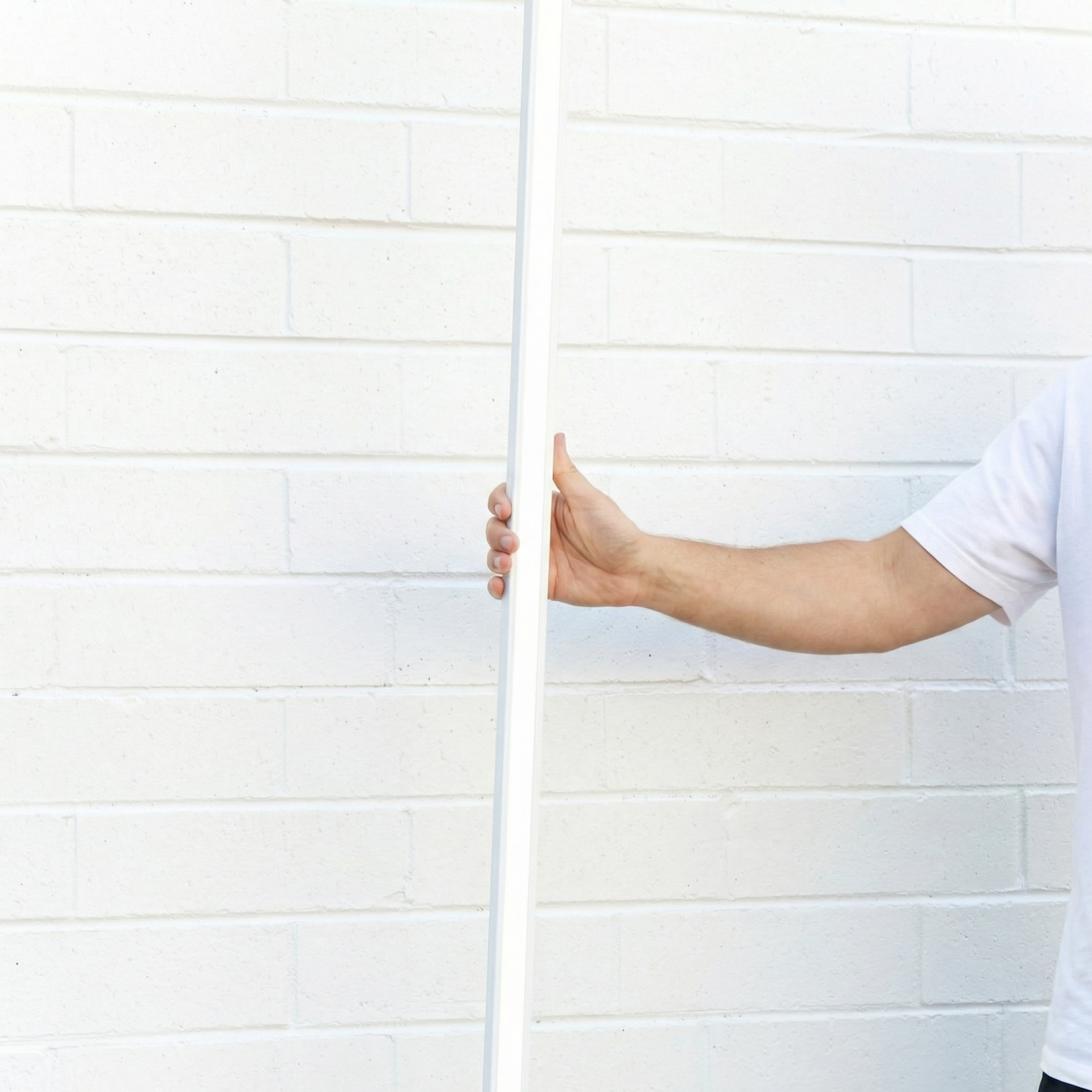 Darlinghurst White Track light held upright against a white brick wall