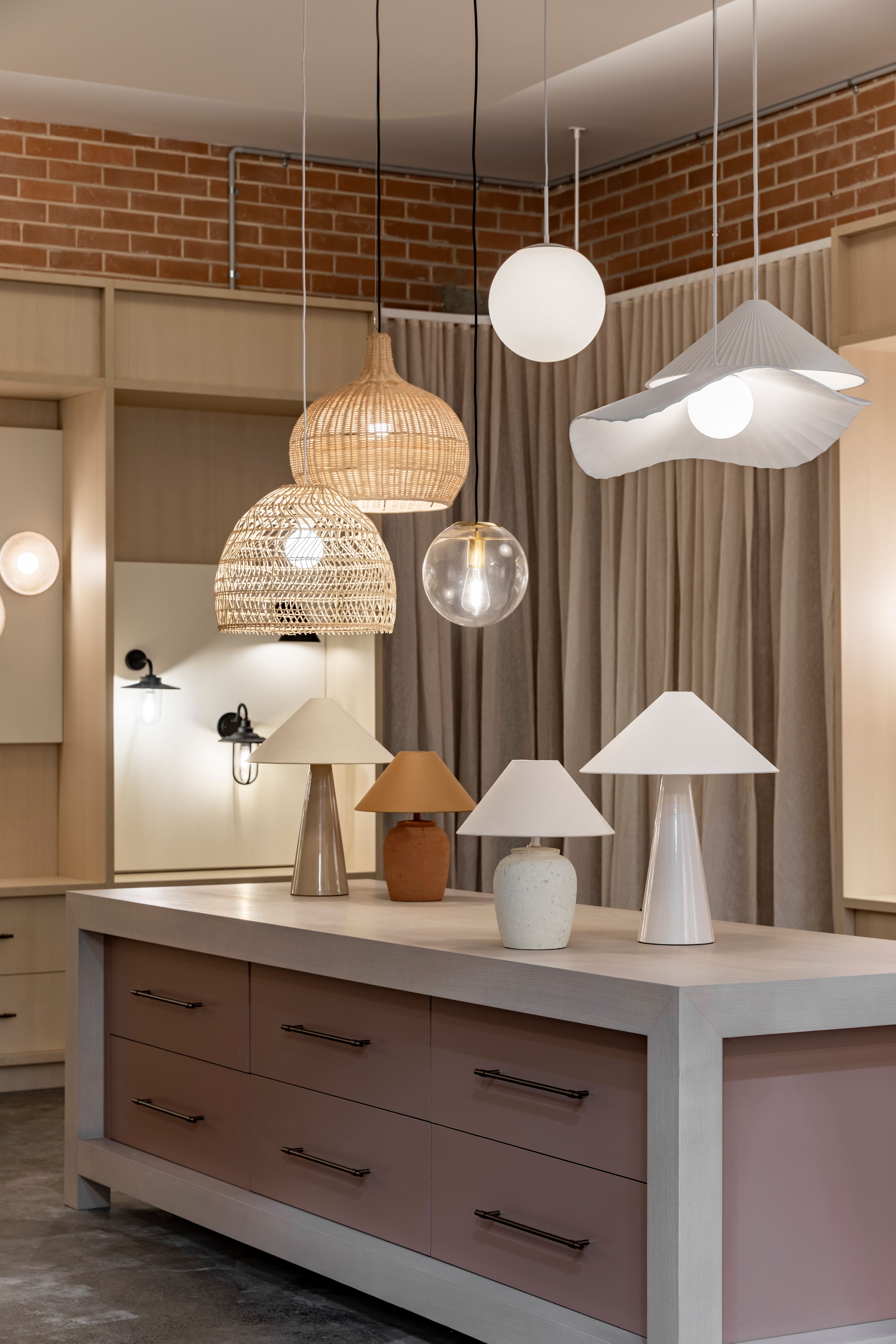 Lighting showroom with pendant lights above a display island of table lamps