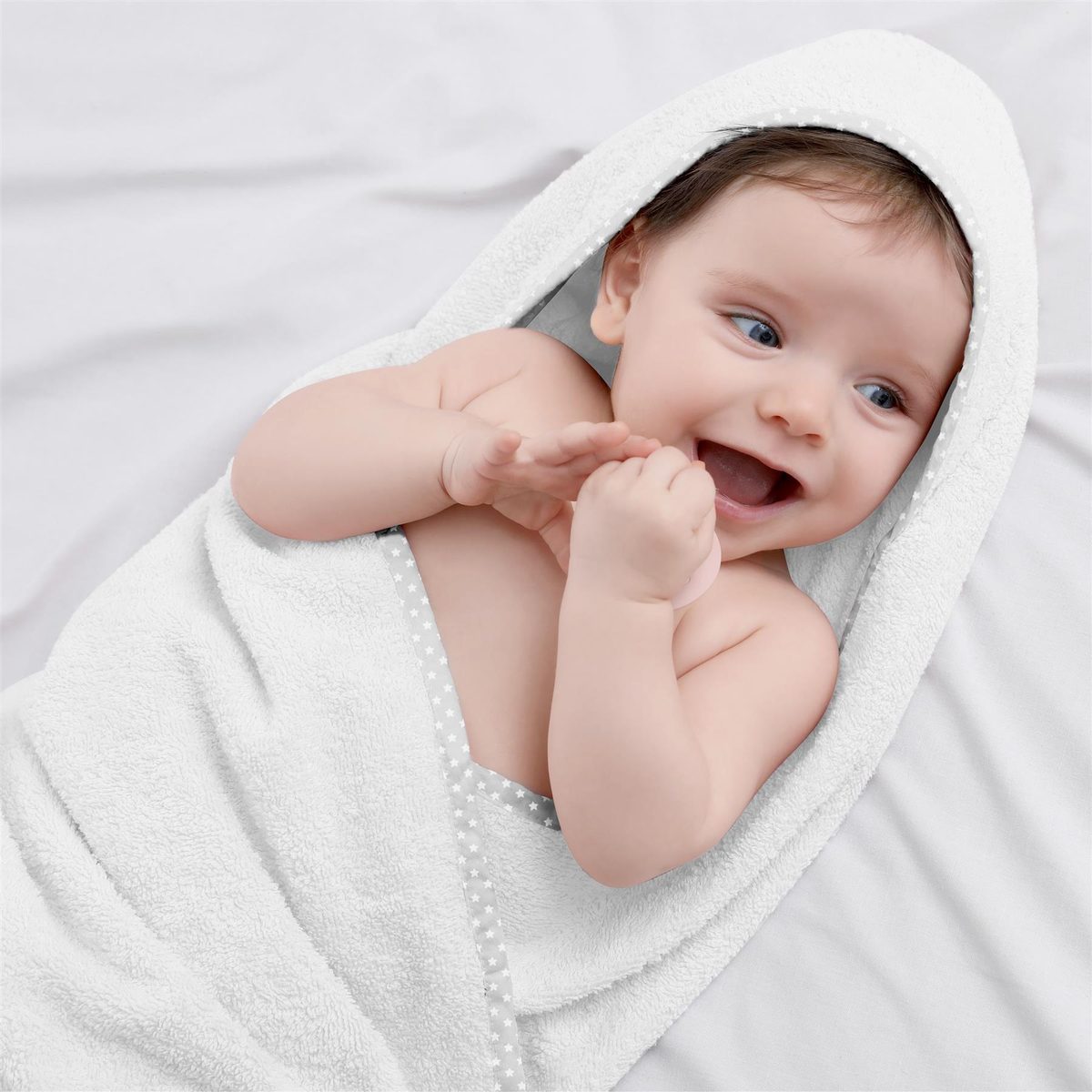 Bébé enveloppé dans une serviette claire après le bain.