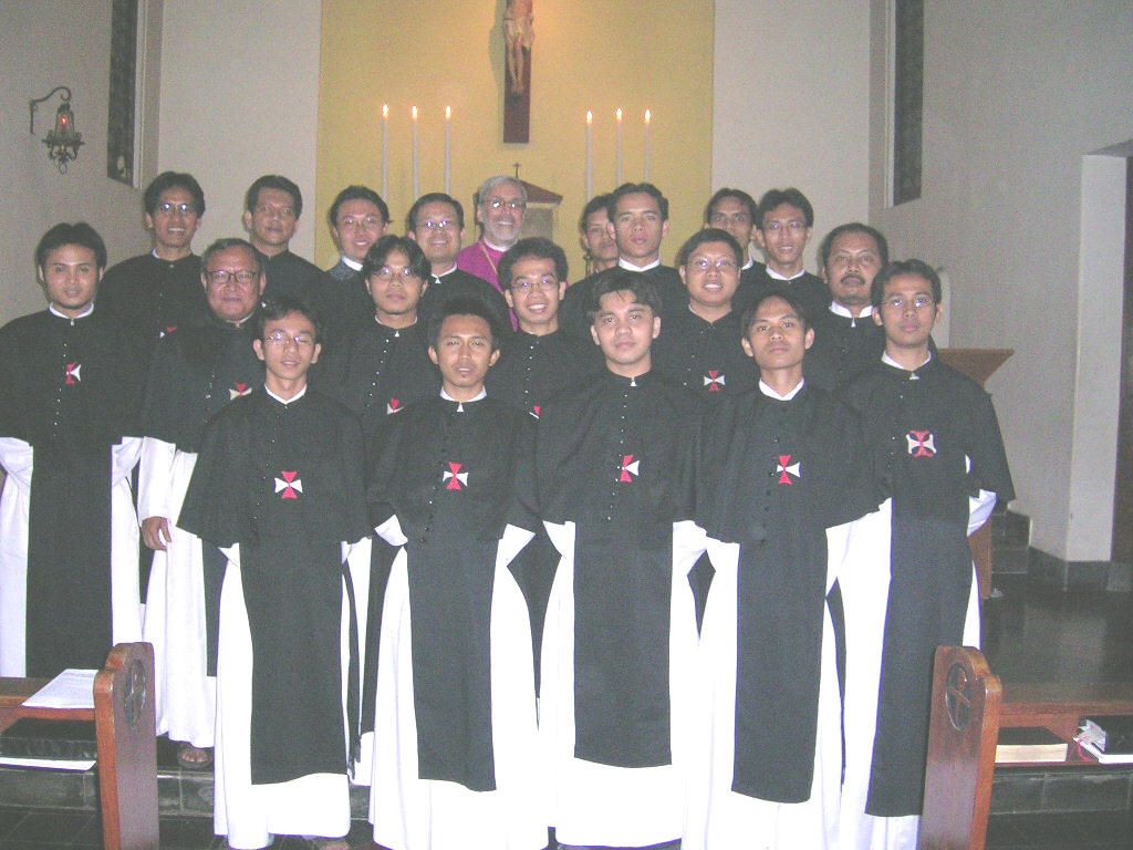 Para frater Krosier berjubah hitam-putih berfoto bersama seorang uskup di depan altar kapel.