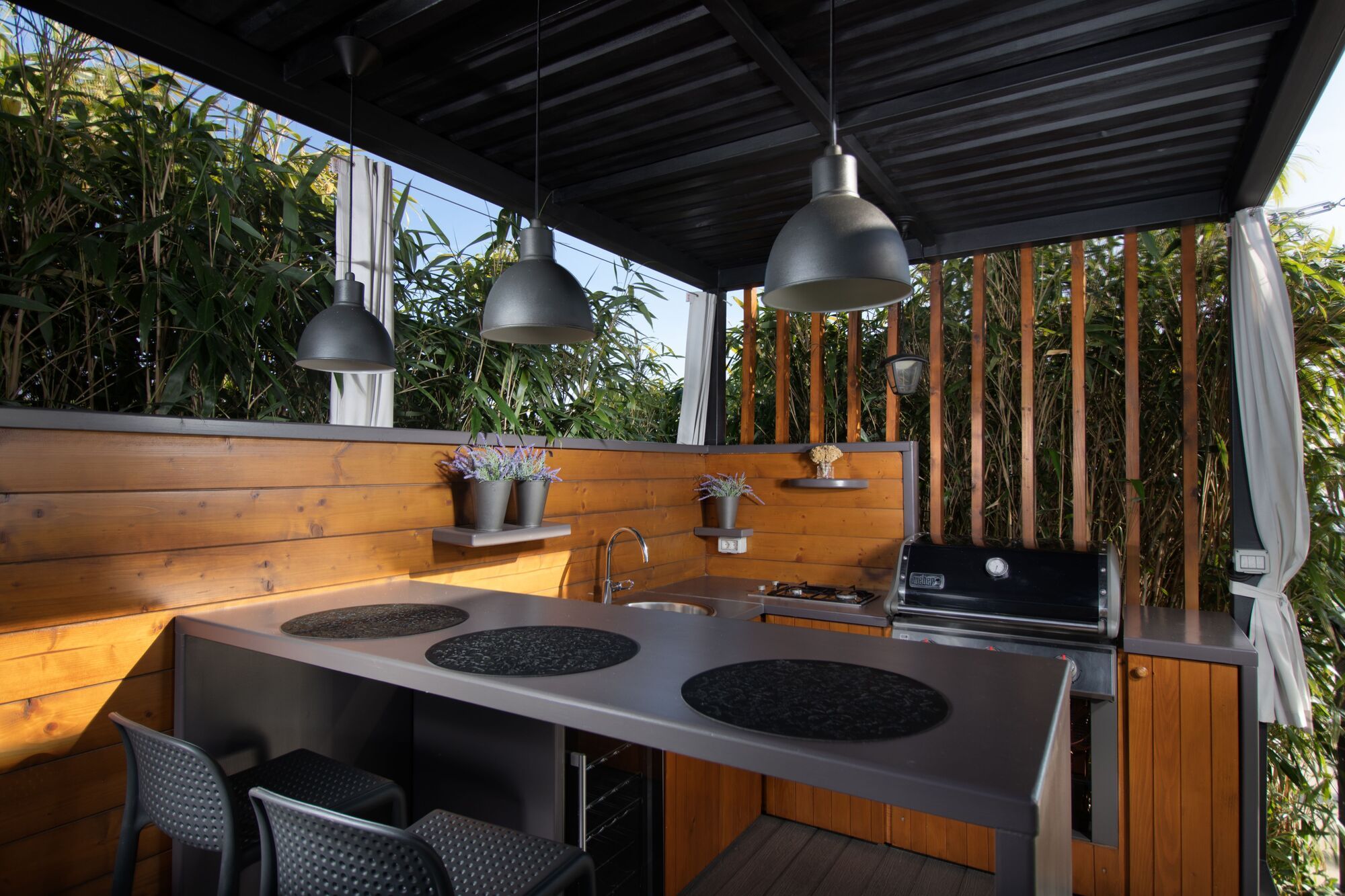 Covered outdoor kitchen with grill and bar