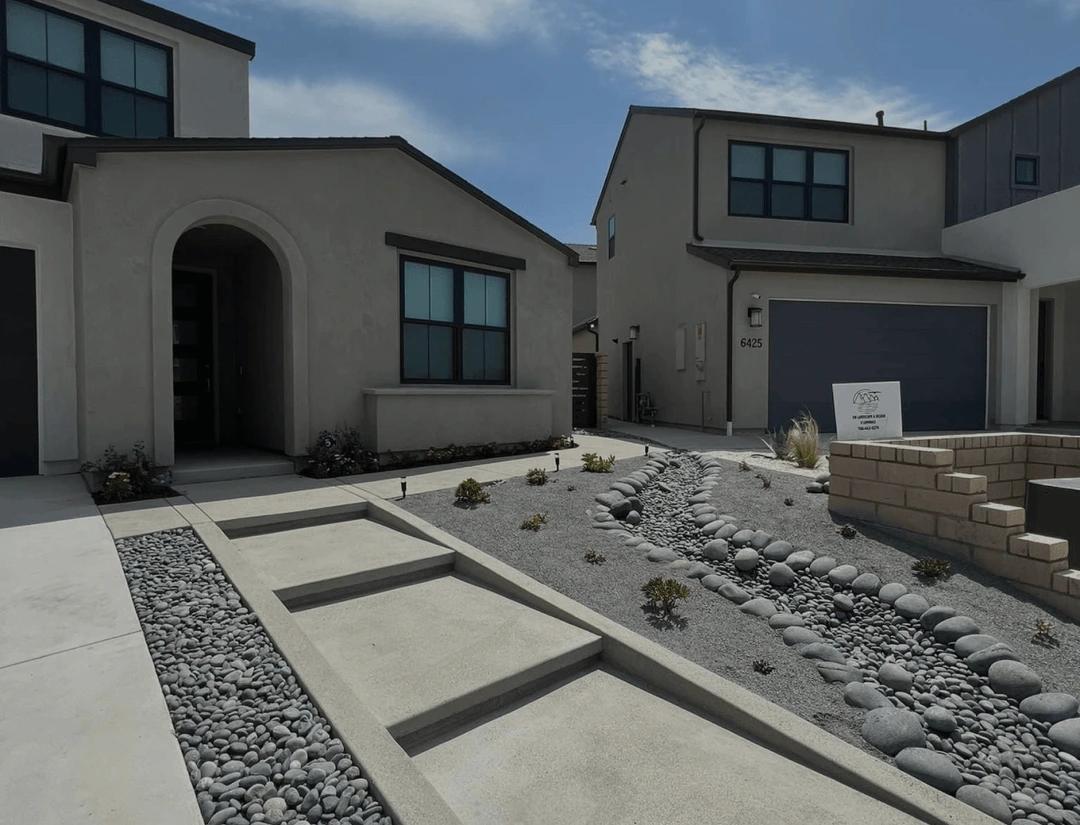 Concrete walkway with a river-rock dry creek bed