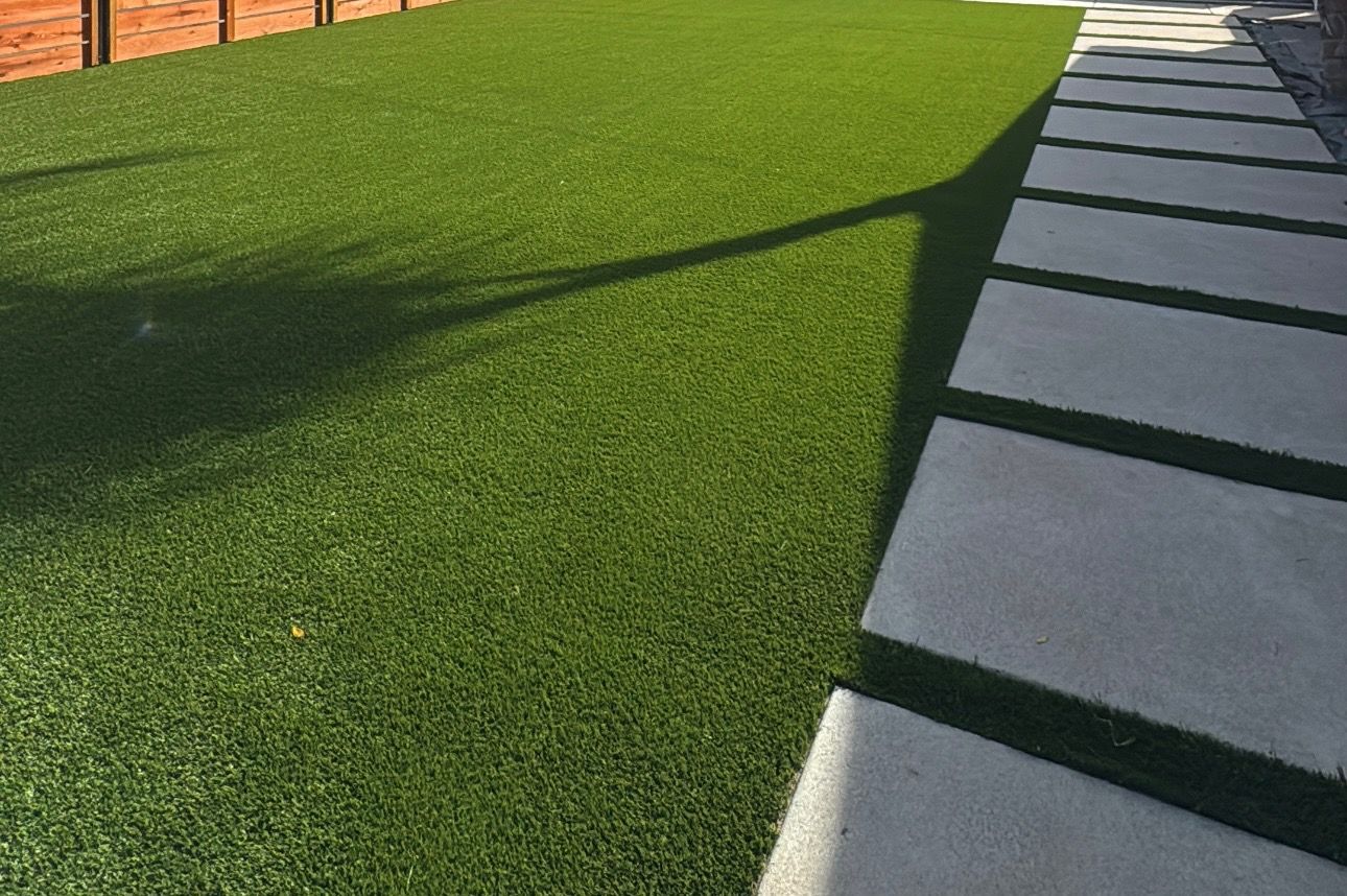 Artificial turf lawn bordered by paver pathway