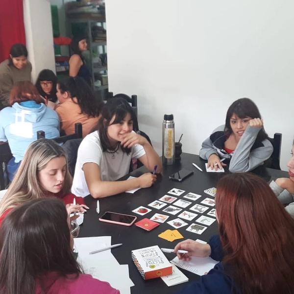 Grupo de personas jugando con cartas en la mesa