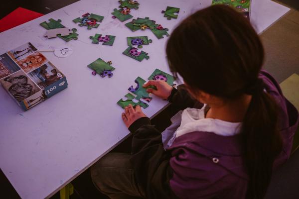 Una niña jugando con un rompecabezas de insectos.