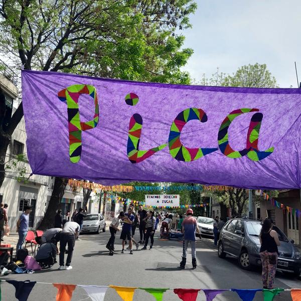 Personas jugando en la calle y un cartel con la palabra Pica