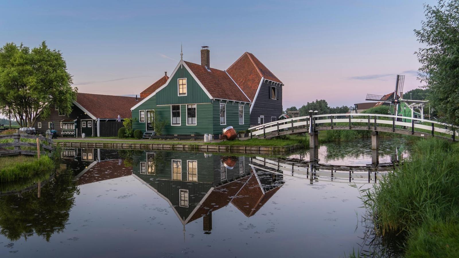 Scenic view of a traditional Dutch house with a reflection on a canal in Zaandam, Netherlands