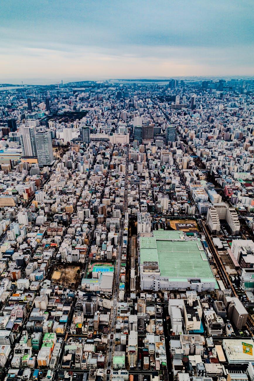 Aerial view of dense city blocks with a green sports field below